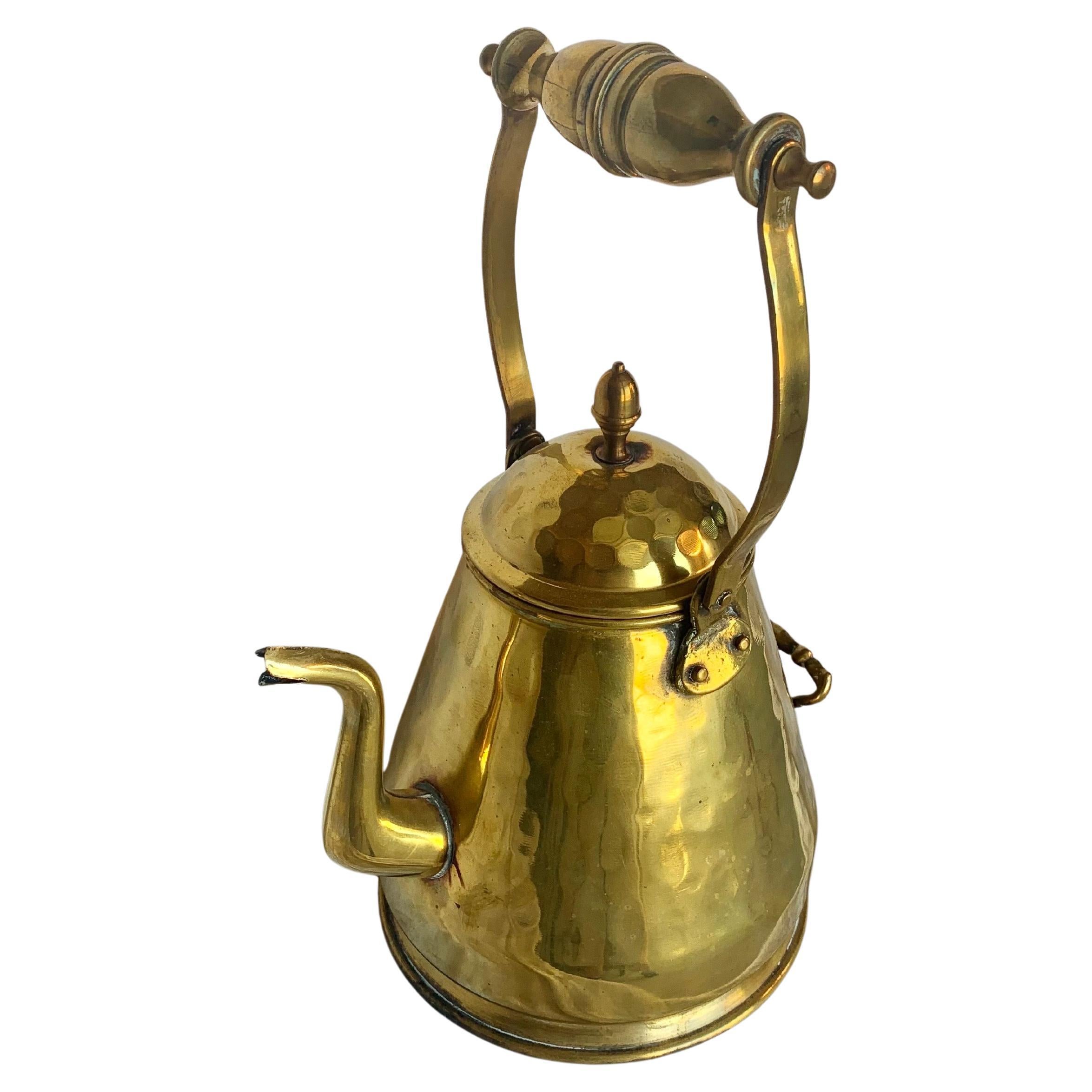 Cette bouilloire du XIXe siècle a été fabriquée en laiton par des artisans à la fin des années 1800. La pièce comporte deux poignées aux détails complexes qui mènent à la bouilloire. Les coutures sont toutes soudées à la main et le design a été
