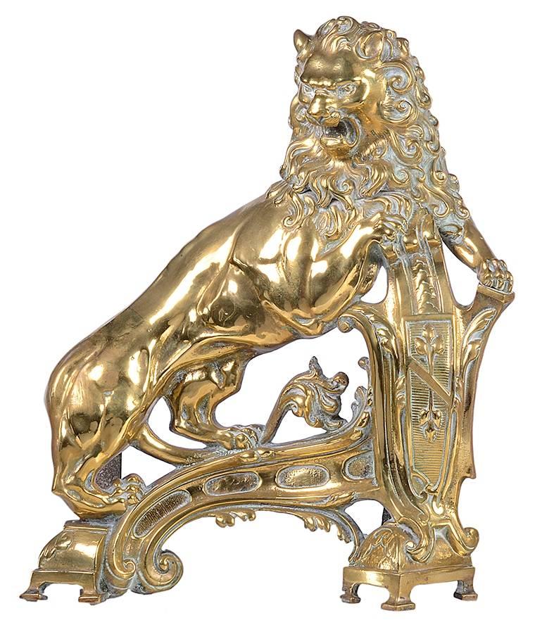 A very impressive pair of 19th century brass fire dogs of rampant lions above armorial shields and scrolling bases.