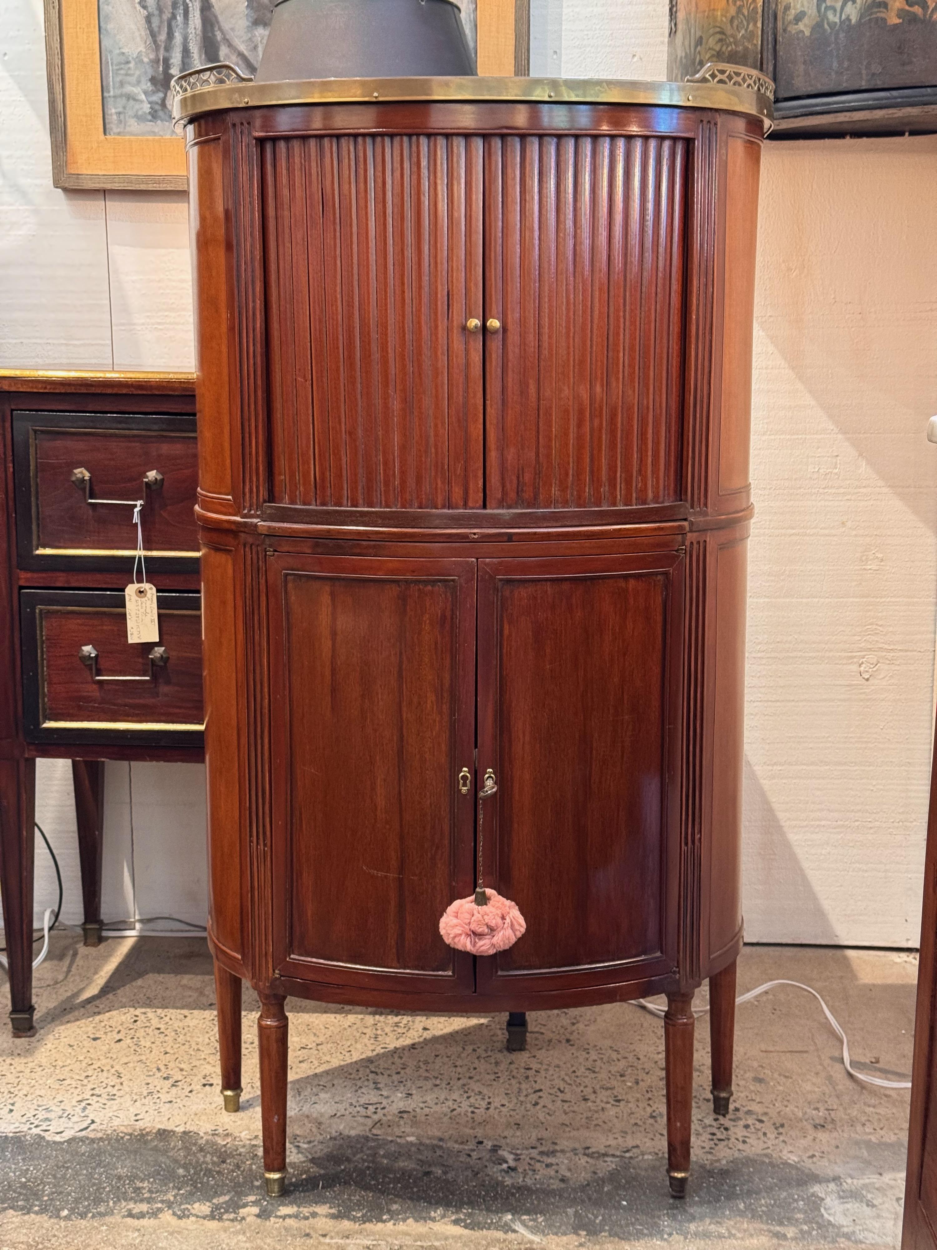 Ein ungewöhnlicher Demi Lune-Schrank. Er hat Rolltüren und eine Marmorplatte.