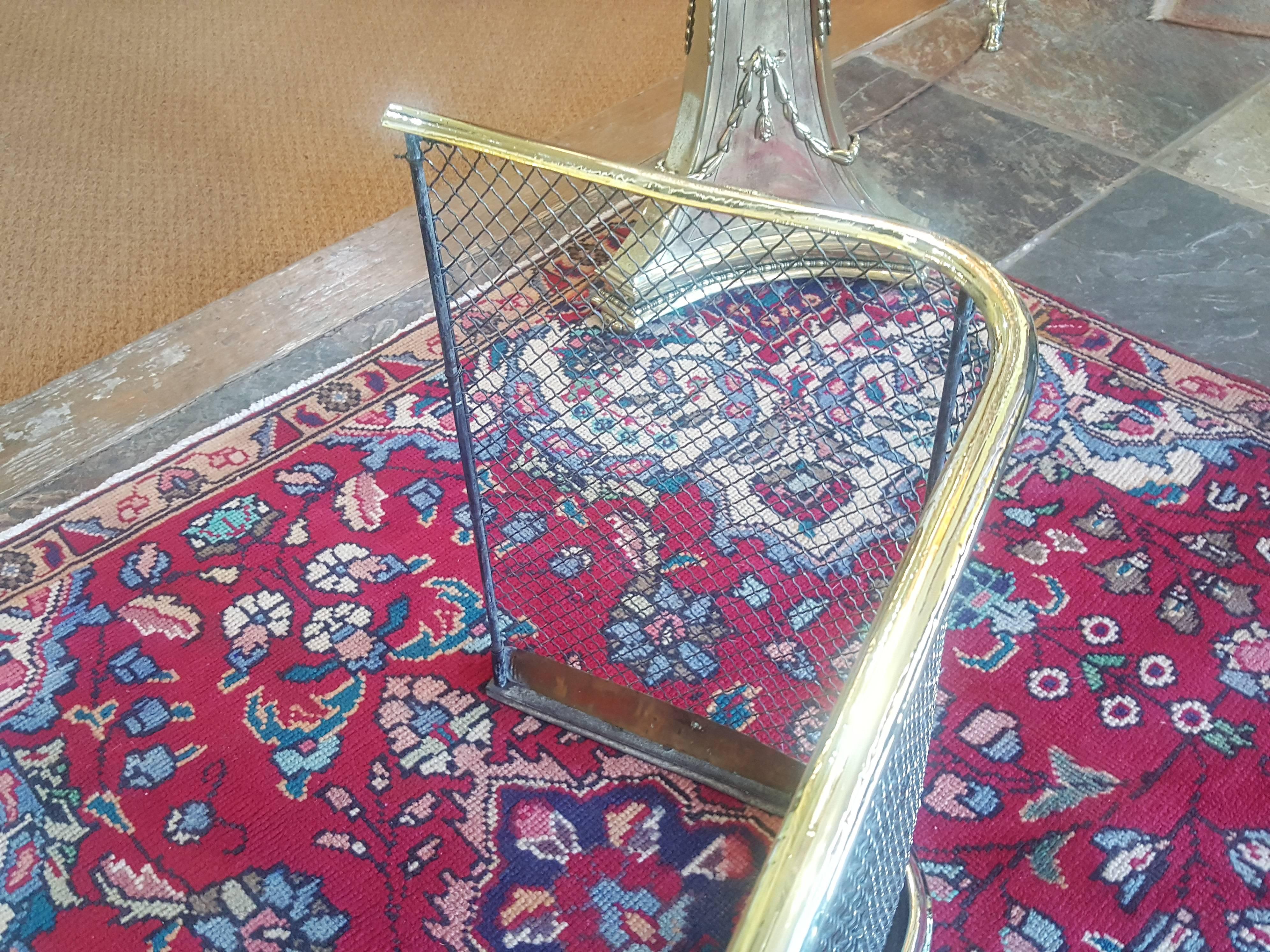 A 19th century brass work fire guard of curved form, the mesh front and curved front and sides raised on a base with flat top,
Measures: 28