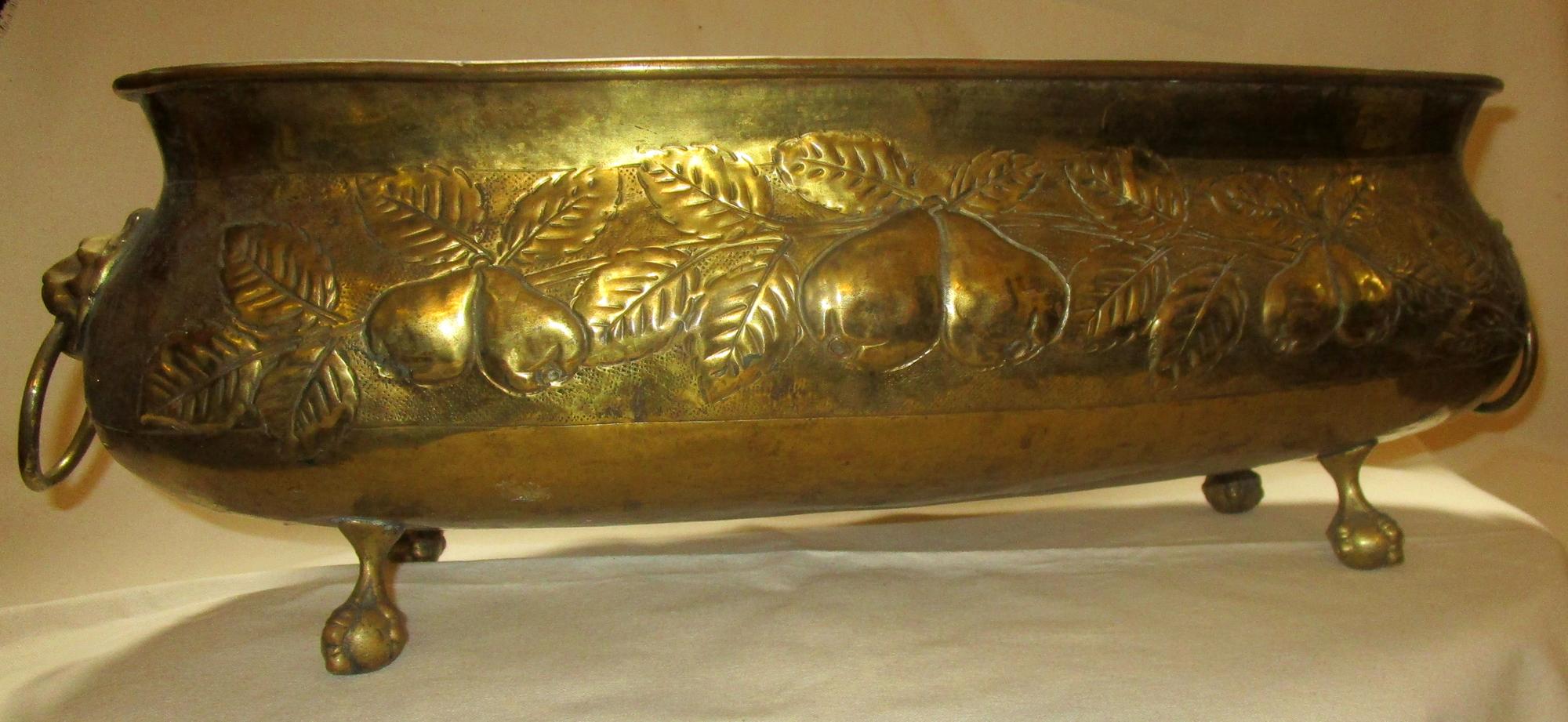 Large sized French brass oval jardinière planter featuring detailed clusters of pears in high relief, ball and claw feet and lion's head ring handles. Very nice old patina, not highly polished.
See measurements below.