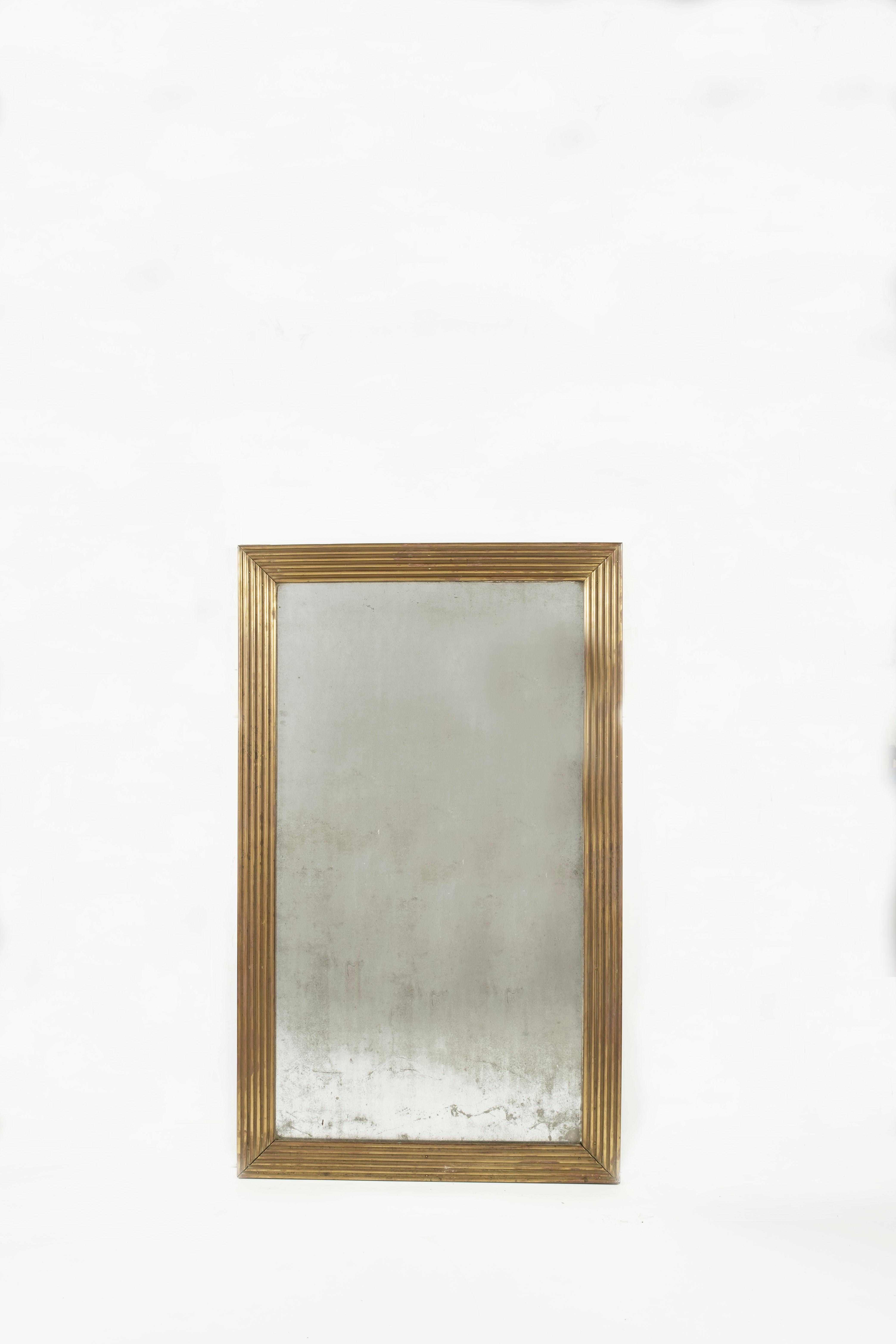A fabulous tall late 19th-century French mirror crafted in a reeded brass frame with wonderful minimalist lines, notable features include original mercury mirror plate.