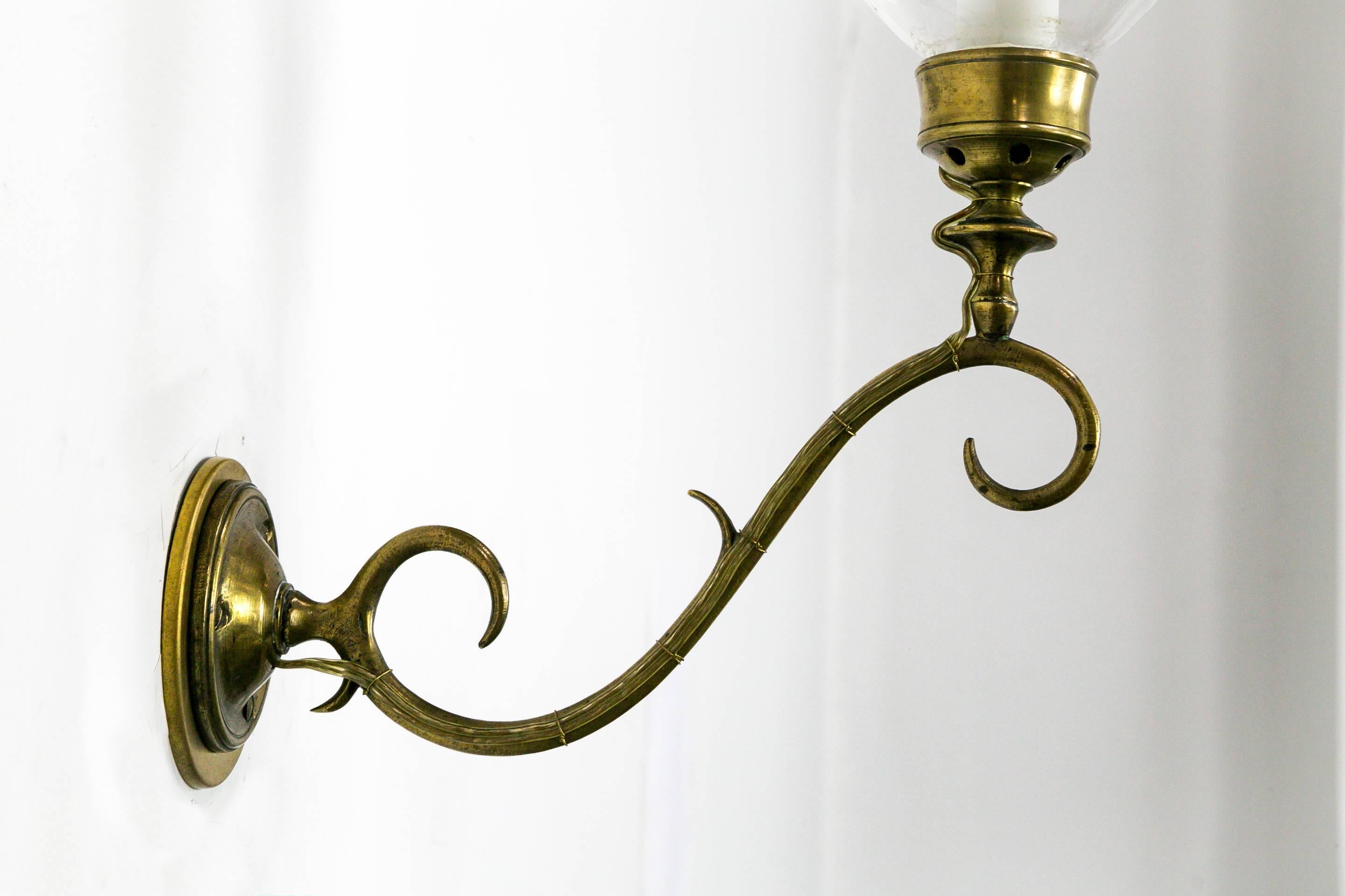 These Anglo-American Hurricane sconces are brass with a refined scroll arm and delicate, hand blown glass shades. The glass and brass complement each other displaying an artfully designed, sophisticated shape, circa 1890. 6