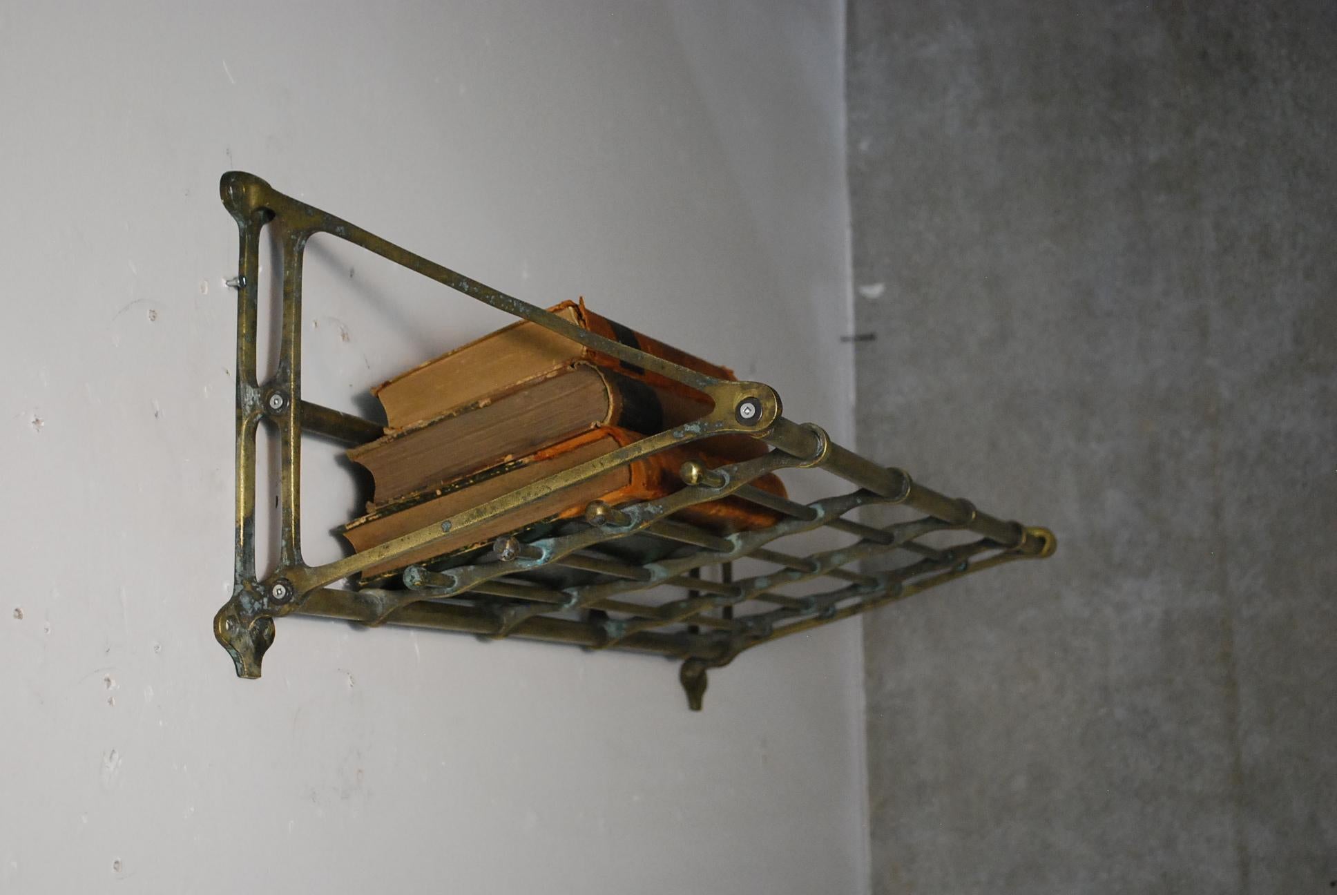 Featuring a beautiful petite antique brass train car luggage racks from the late 19th century, early 20th. The patinated brass is consistent with age and use and has not been touched. The rack features an open, tubular shelf supported by two