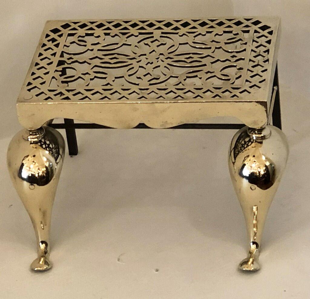 19th century brass and iron trivet/footman with wonderful cast pierced top. The stand is raised on cabriole legs with a wonderful shaped frieze.