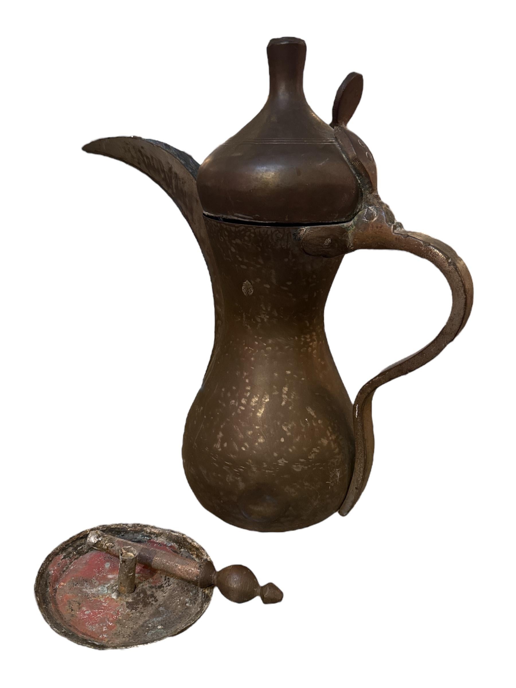 Excelente ejemplo de la artesanía tradicional de Oriente Próximo, esta cafetera turca de latón del siglo XIX, o dallah, refleja el arte y la herencia cultural de la época otomana. Forjada a mano con maestría en latón macizo, presenta un caño