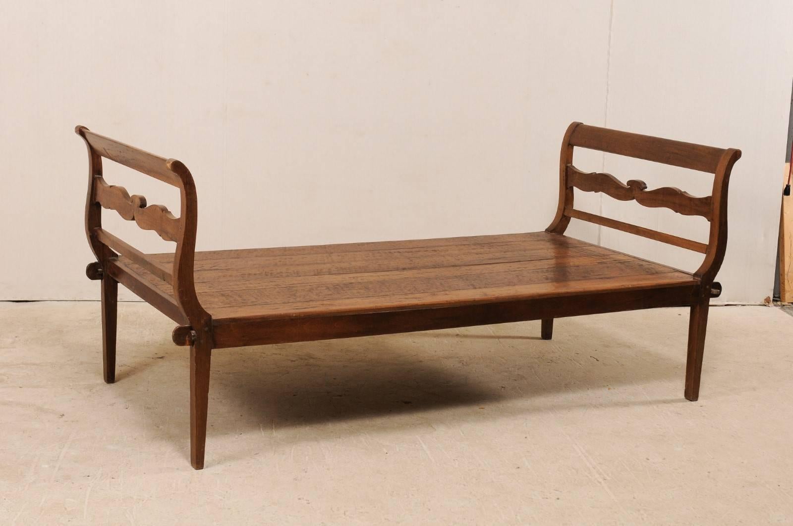A Brazilian 19th century peroba wood daybed. This nicely-sized antique daybed from Brazil features curvy slatted head and foot boards, with a beautifully carved center slat. The peroba wood, which is a tropical native hardwood to Brazil that is 35%