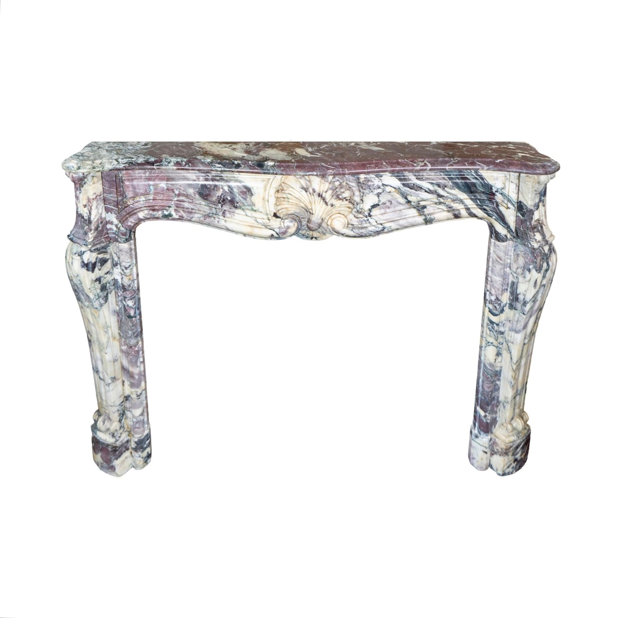 Expertly crafted from 1820 French Villefranche Peach Flower Marble, this marble mantel boasts intricate carvings and a stunning carved shell motif. Enhance your home's aesthetic with this timeless and elegant piece.