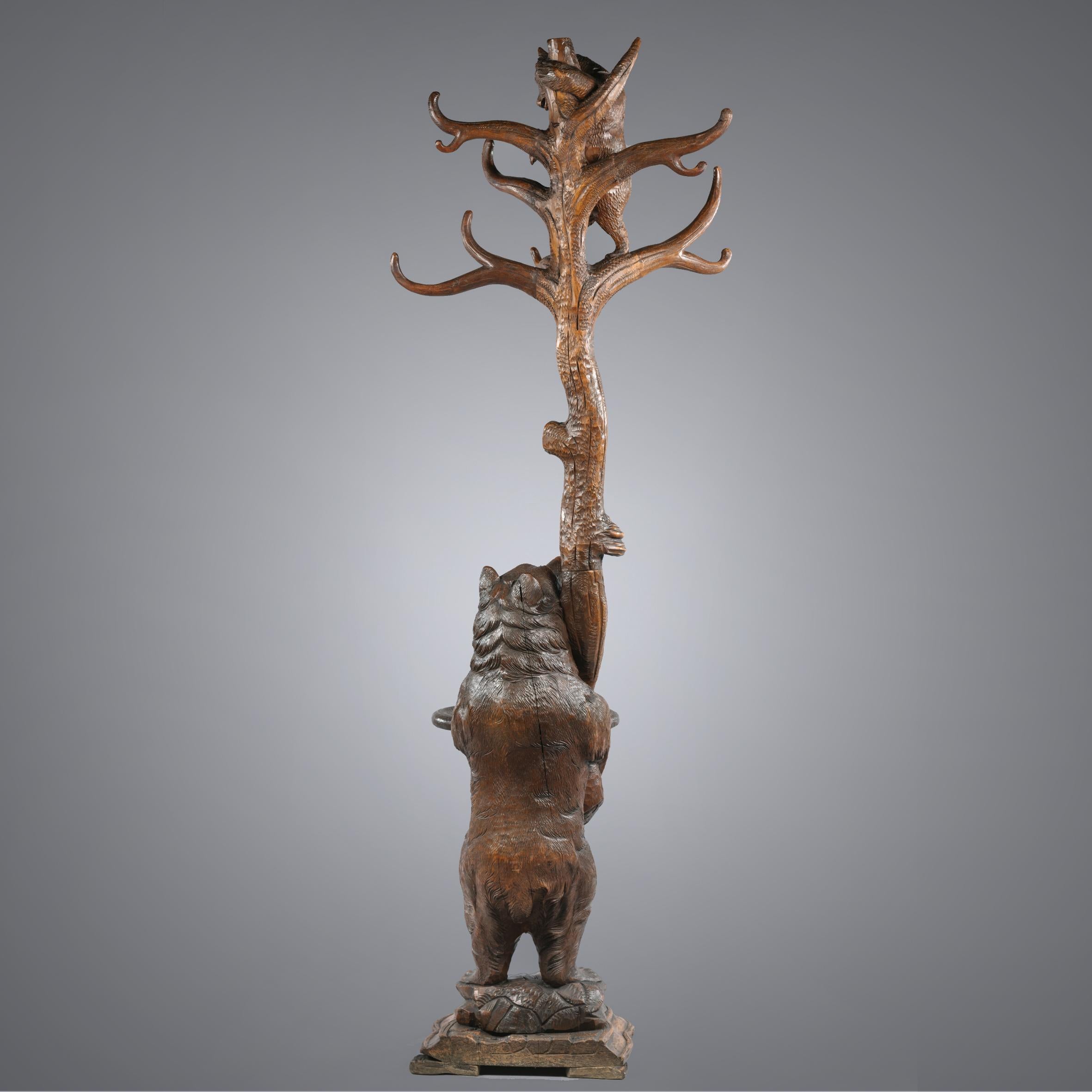 A fine 19th Century Brienz Black Forest hand-carved bear hall stand.

This charming hall stand is naturalistically carved in Linden wood and depicts a standing Black Forest bear next to a tree, with open mouth and eyes watching its young cub in