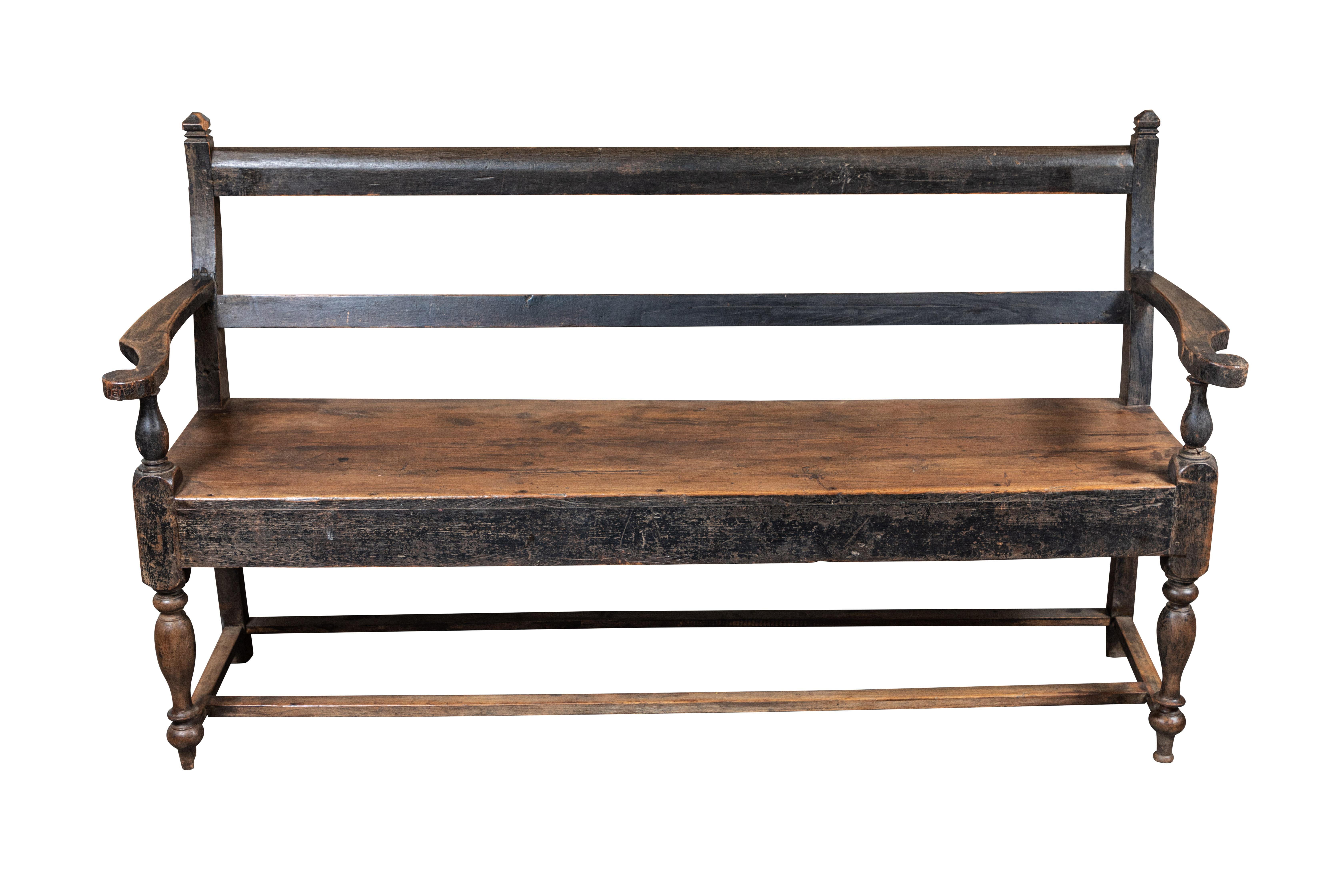 19th century British Colonial teak bench with worn black finish from India.