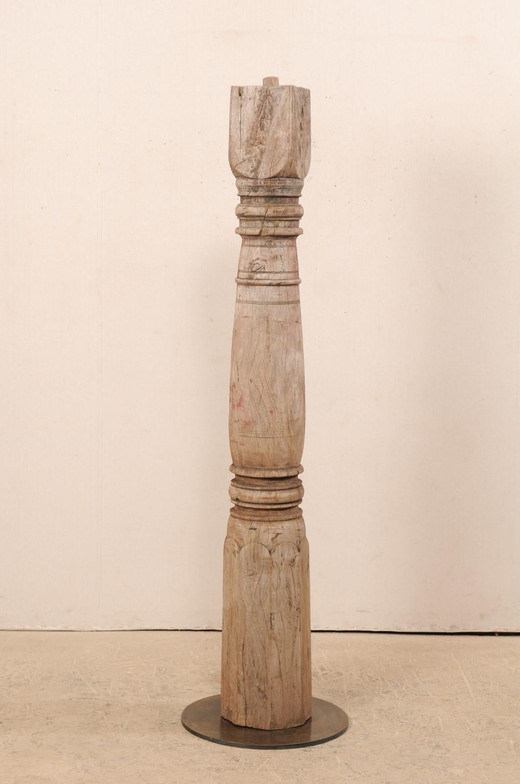 A single 19th century British Colonial carved wood column with custom stand. This antique hand carved wooden architectural element from India, which stands just over 6 feet in height, features a shapely body adorn with a series of carved rings an