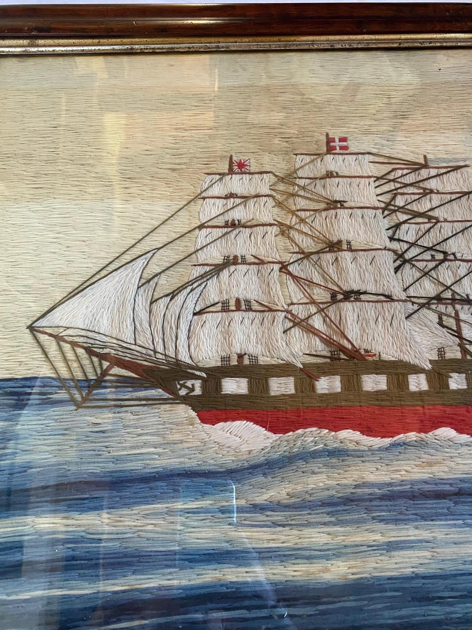 19th century British Sailor’s Woolie of a Ship-of-the-Line, circa 1840, depicting a fully rigged ship under full sail, with Union Jack on foremast peak, Admiral’s pennant on the Main, and signal flags and Red Ensign strung off backstay; mounted in a