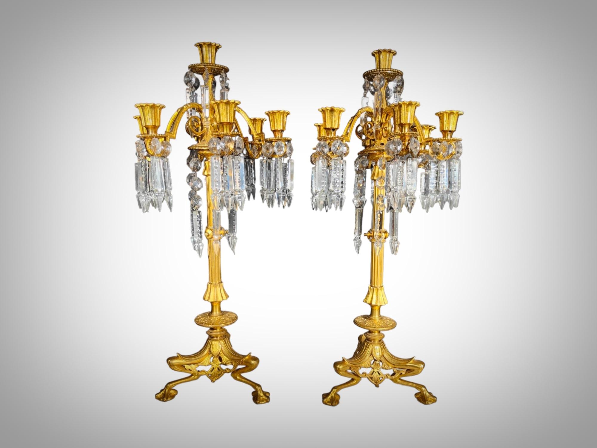 Immerse yourself in the opulence of the 19th century with these stunning candelabras, a masterful fusion of gilded bronze and wheel-cut crystals. Every detail of these candelabras evokes an era of artistic refinement and splendor, creating a piece