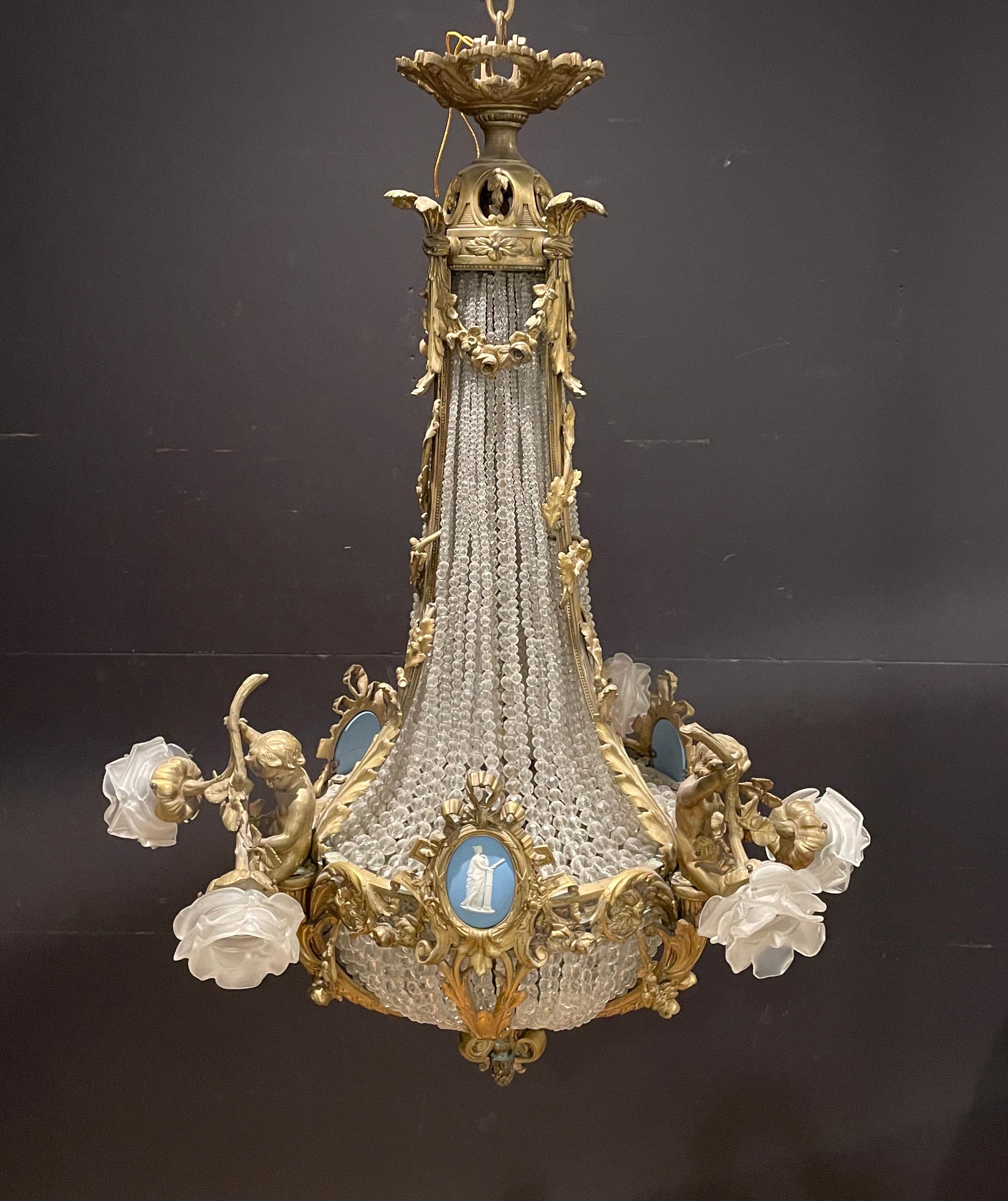 Finest quality Louis XVI 19th century gilt bronze and crystal chandelier with putti and classical Wedgwood porcelain plaques with women. Six exterior lights with rose bud glass shades. Three interior lights illuminate the crystal basket and upper