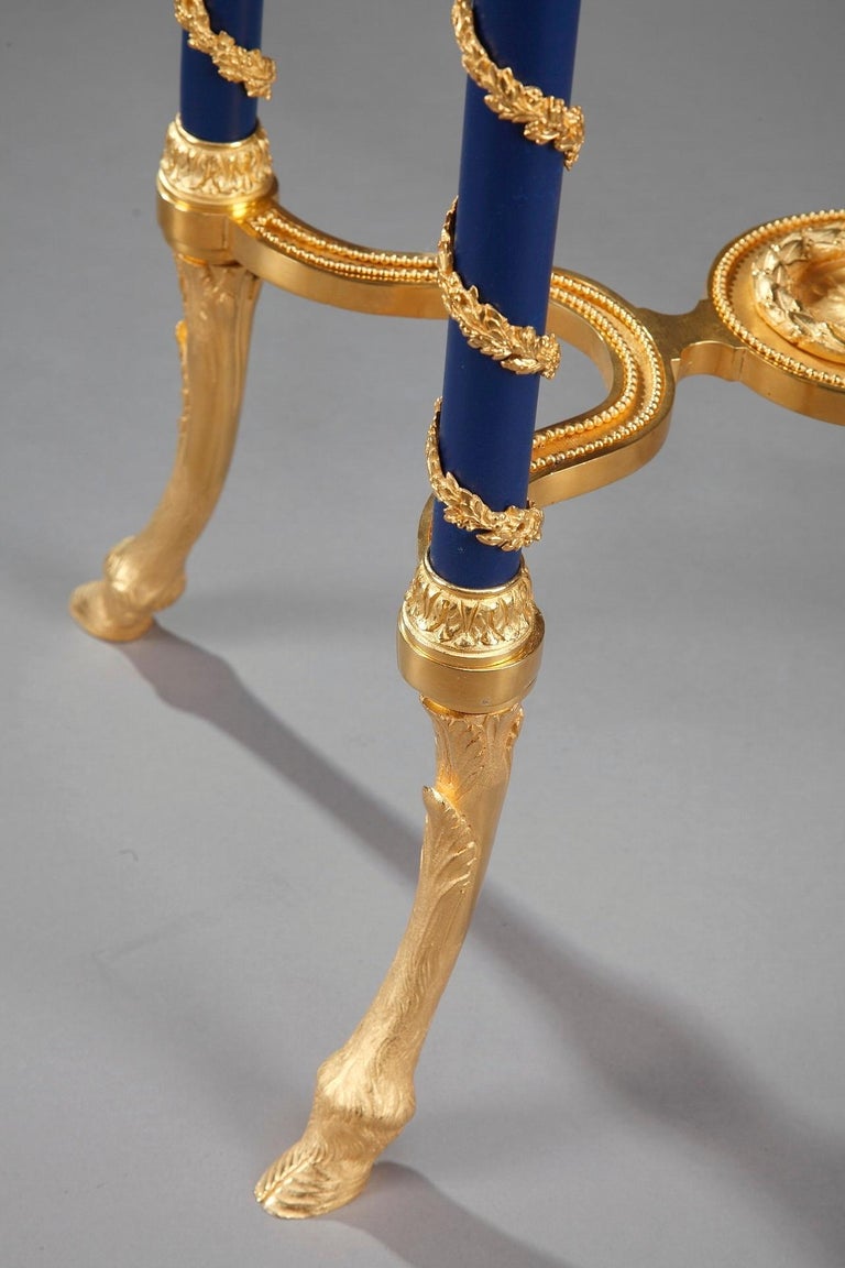 Marble gueridon table with oval tray ornamented with gilt bronze foliate interlacing on dark blue background, and masks. The table is resting on four curved feet decorated with ormolu twisted branches, ending with hoof legs, late 19th century French