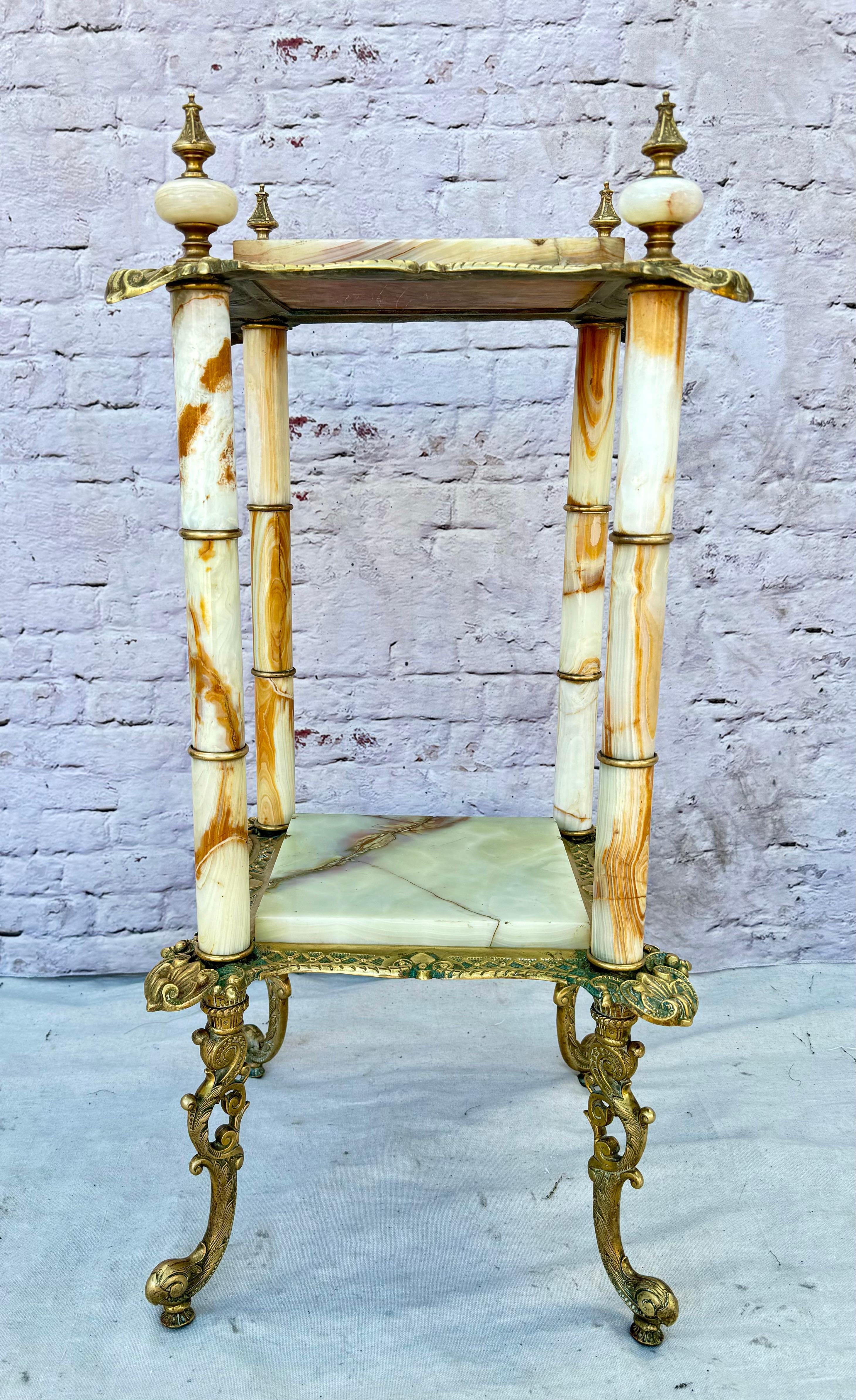 Support à plantes en bronze et en onyx du XIXe siècle. Le socle est lourd et comporte deux étagères carrées et plates en onyx dans les tons crème, beige et marron. Le bronze est utilisé pour l'armature et est coulé dans des motifs floraux et des