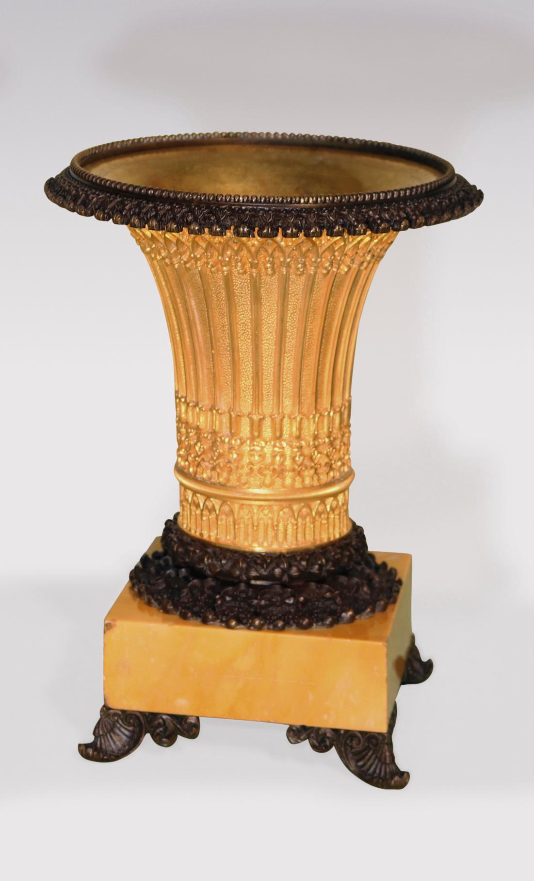 A fine pair of early 19th century bronze and ormolu Gothic style vase-shaped Tazzas, having beaded and berry decorated edges, above intricate arch decorated bodies, supported on sienna marble bases, ending on scrolled feet.