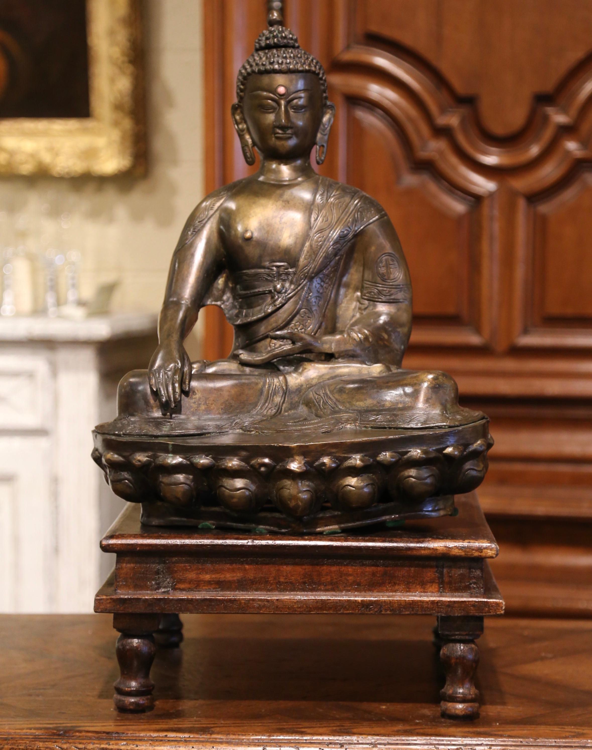 Bring peace and serenity to your home with this elegant antique Buddha. Crafted of bronze in Asia, and resting on a wooden base, the statue depicts a Tara with an Urna on her forehead, symbolizing a 3rd eye, which in turn symbolizes vision into the