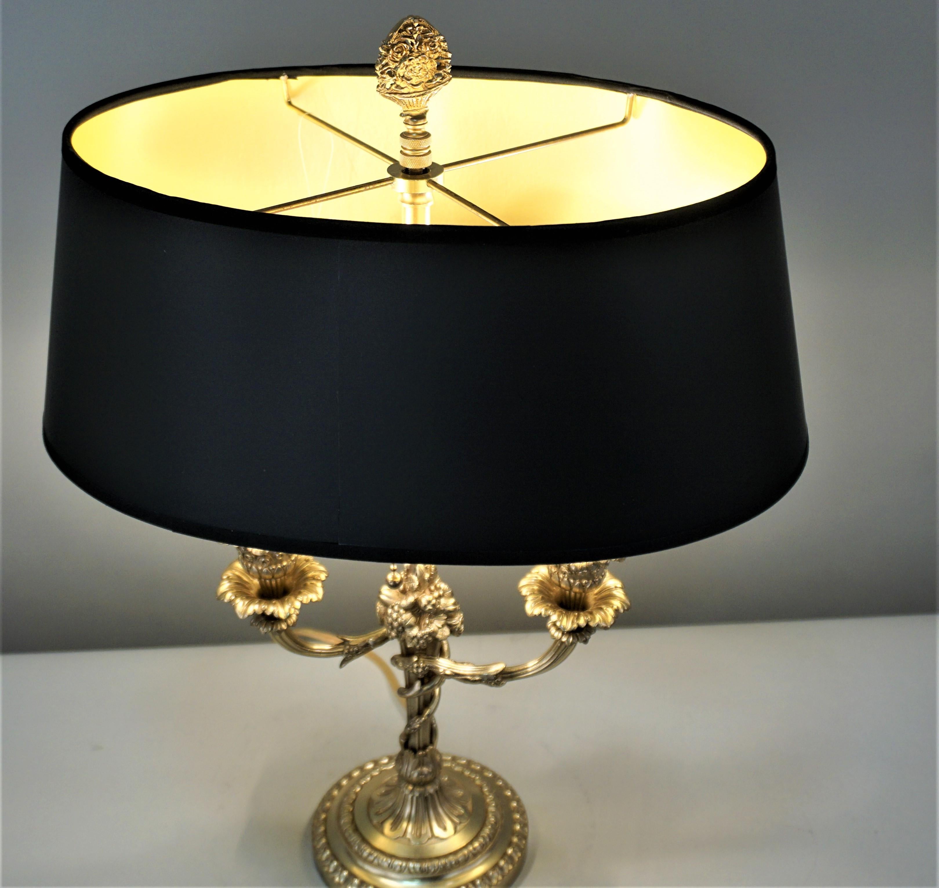 Beautiful 19th century French bronze candelabrum that has been electrified as a table or desk lamp and fitted with oval black gold lining lampshade.
2 pull chain socket.