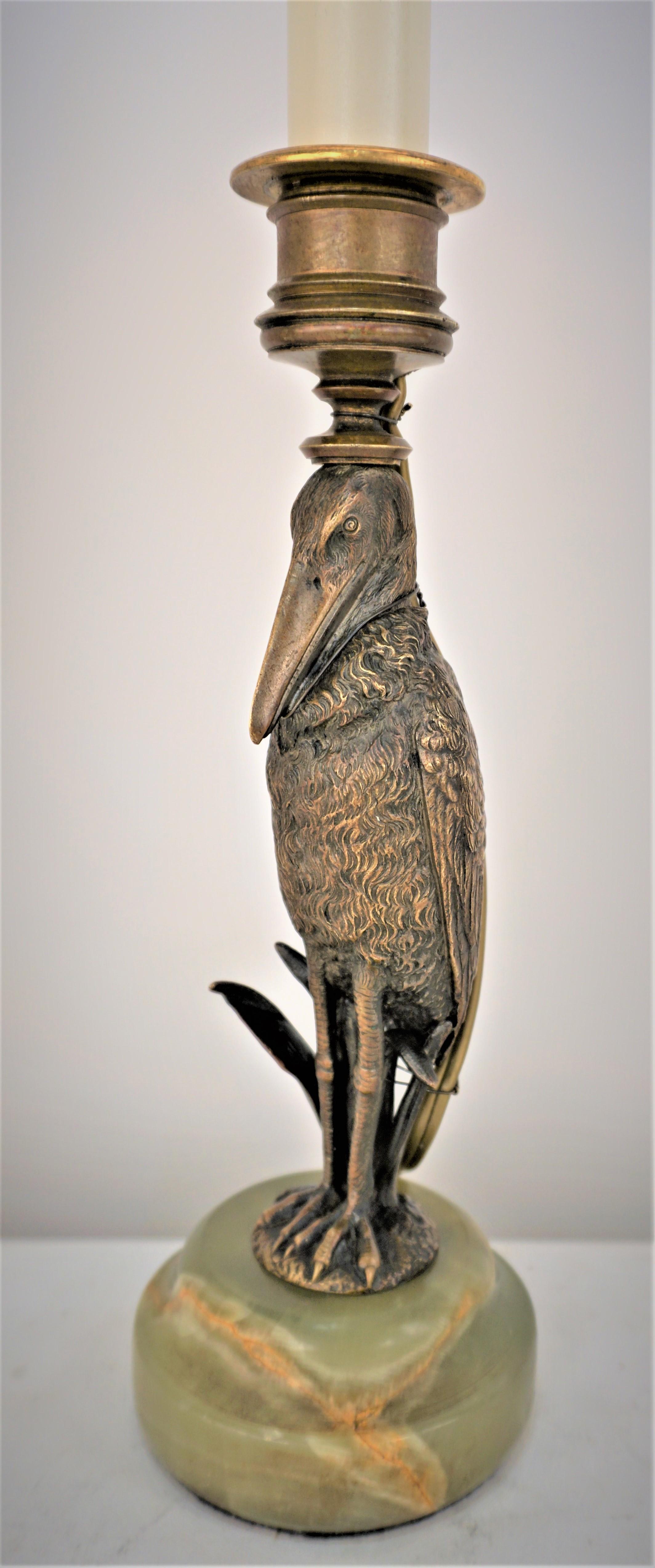 Bronze sculpture pelican standing on round green onyx candlestick that has been electrified and was made to a beautiful table lamp. 