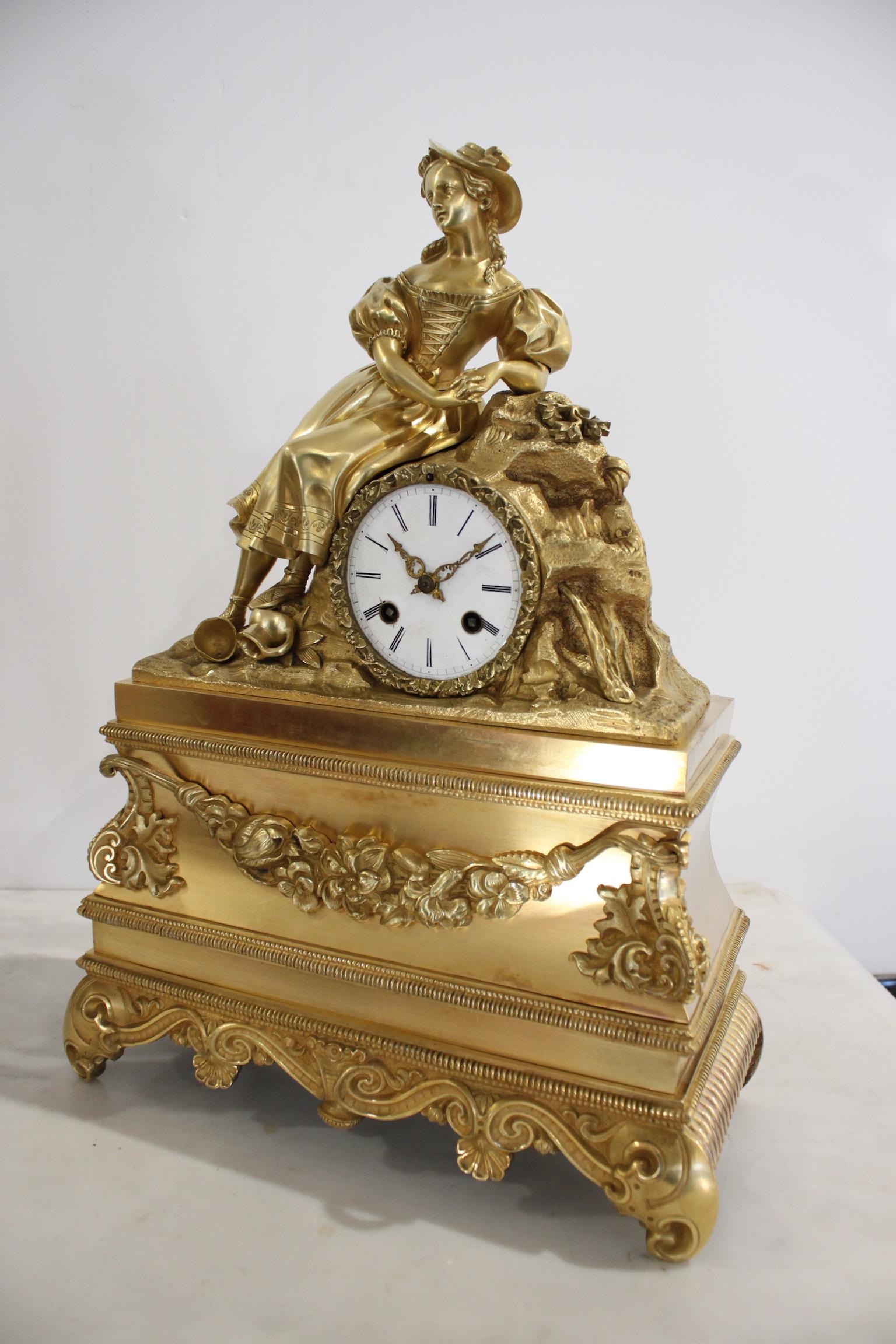 19th century gilt bronze clock representing a woman with reversed jugs. In working order. 
Dimensions: width 32cm, height 44cm, depth 13cm.