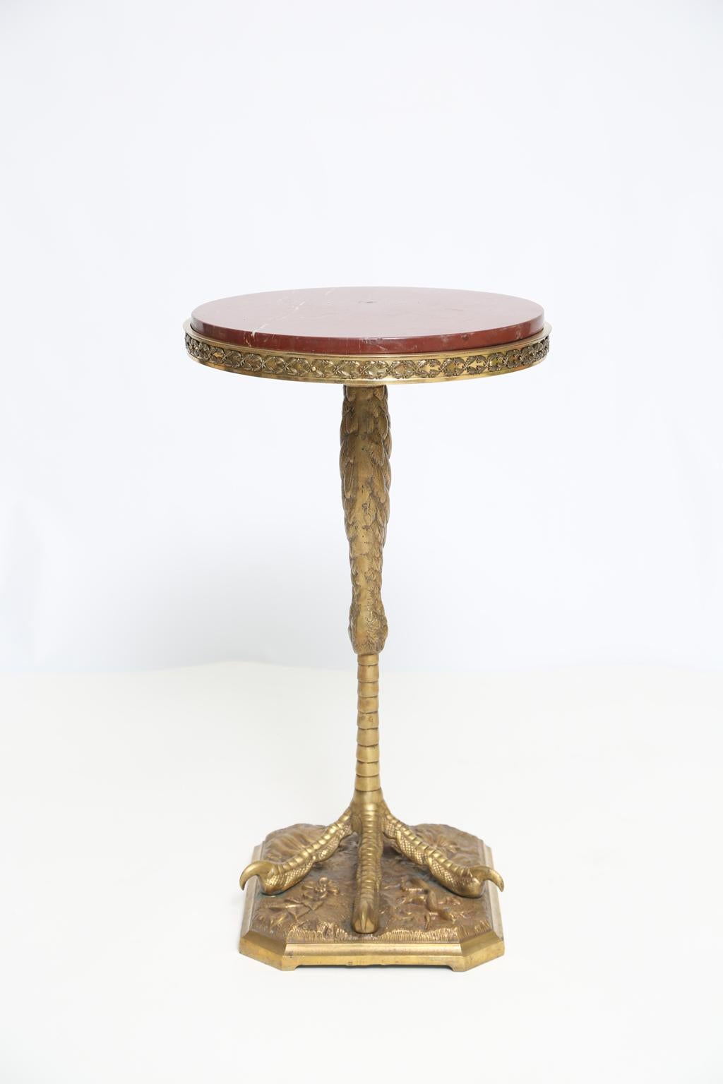 A rare, finely chased, occasional table, by the P.E. Guerin Company (Pierre Emmanuel Guerin, France, United States, 1833-1911), having round top of Rosso Verona marble, inset in bronze frame, raised on beautifully detailed ostrich leg and talon, on