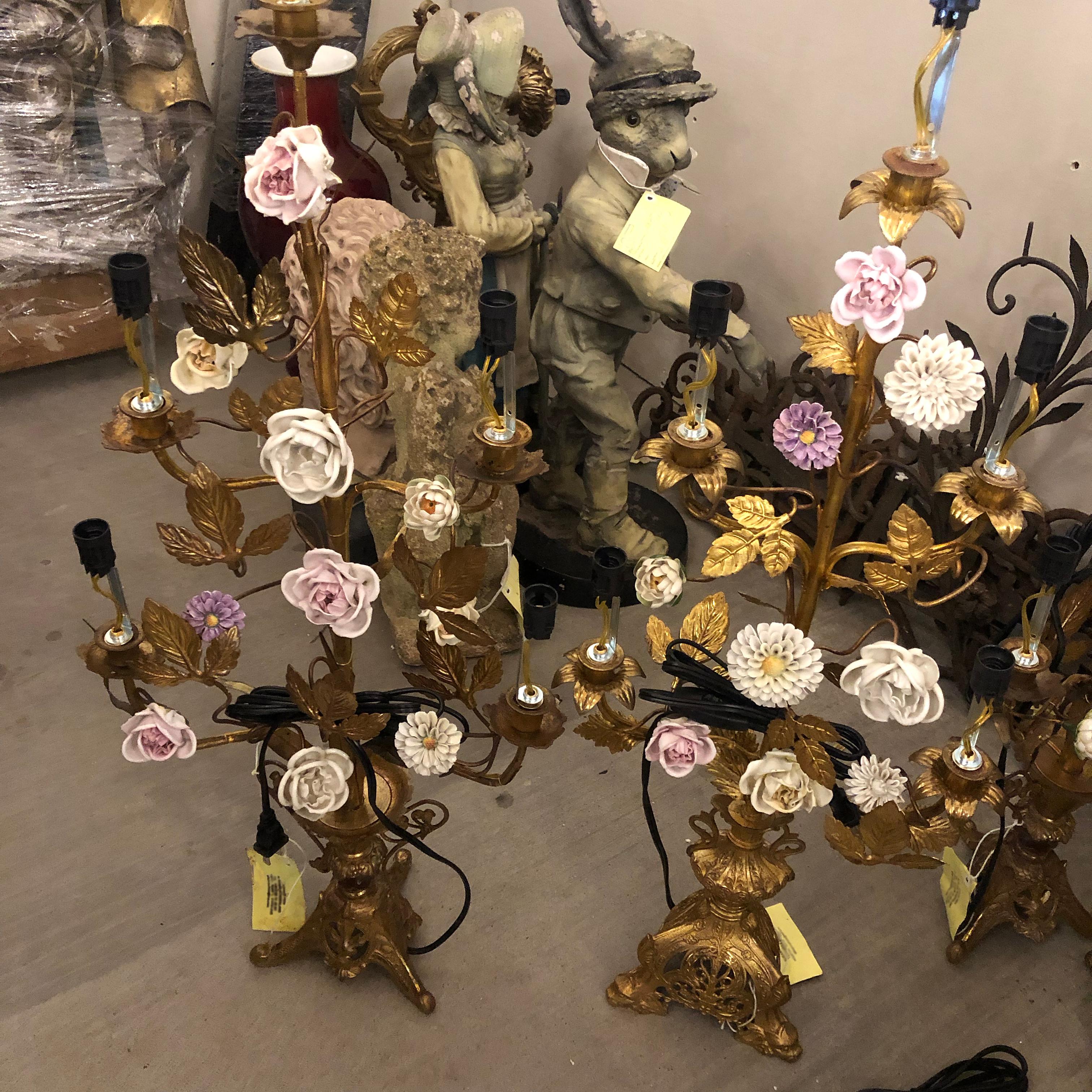 This is a set of four exceptional mood-creating church table candelabras or girandoles with the delightful addition of mixed porcelain flowers. 
The girandoles have been converted from the original candles to candlelights. 
The particular candle