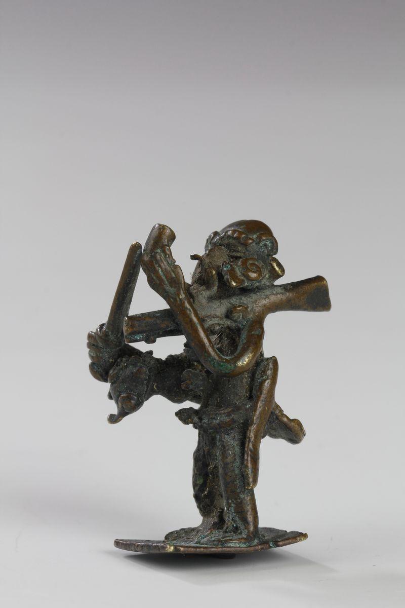 Ce poids en or Akan représente un chasseur traditionnel fumant la pipe. On le voit tenir un couteau et un autre couteau à sa ceinture. Un mousquet est posé en équilibre sur son épaule et une petite gazelle est attachée autour de sa taille.

Période