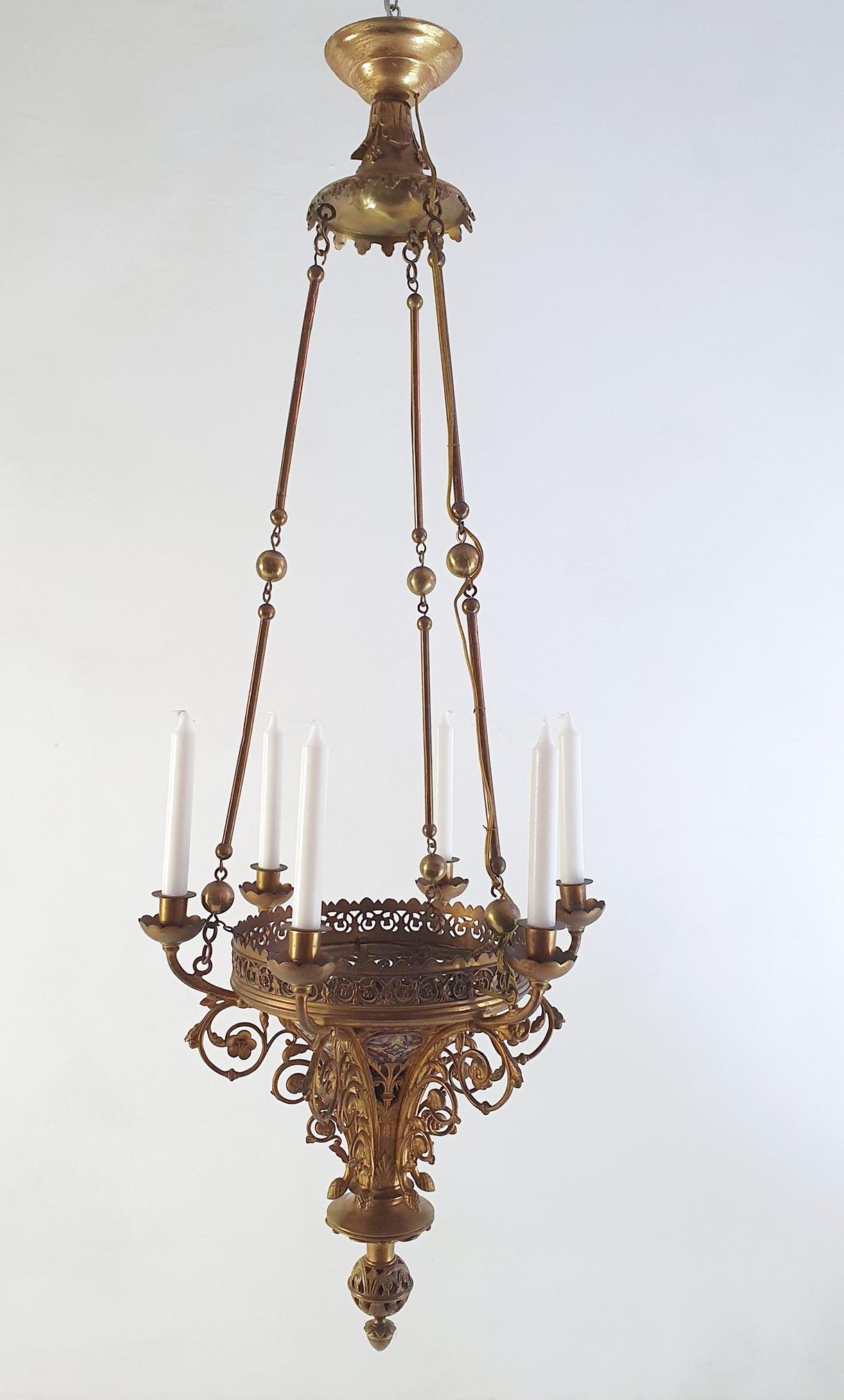 Here we have a slender Gothic Revival bronze church chandelier from the latter part of the 1800's. The chandelier is entirely handmade in cast bronze and has detail in enamel. It is made to hold six standard size candles which give a beautiful glow
