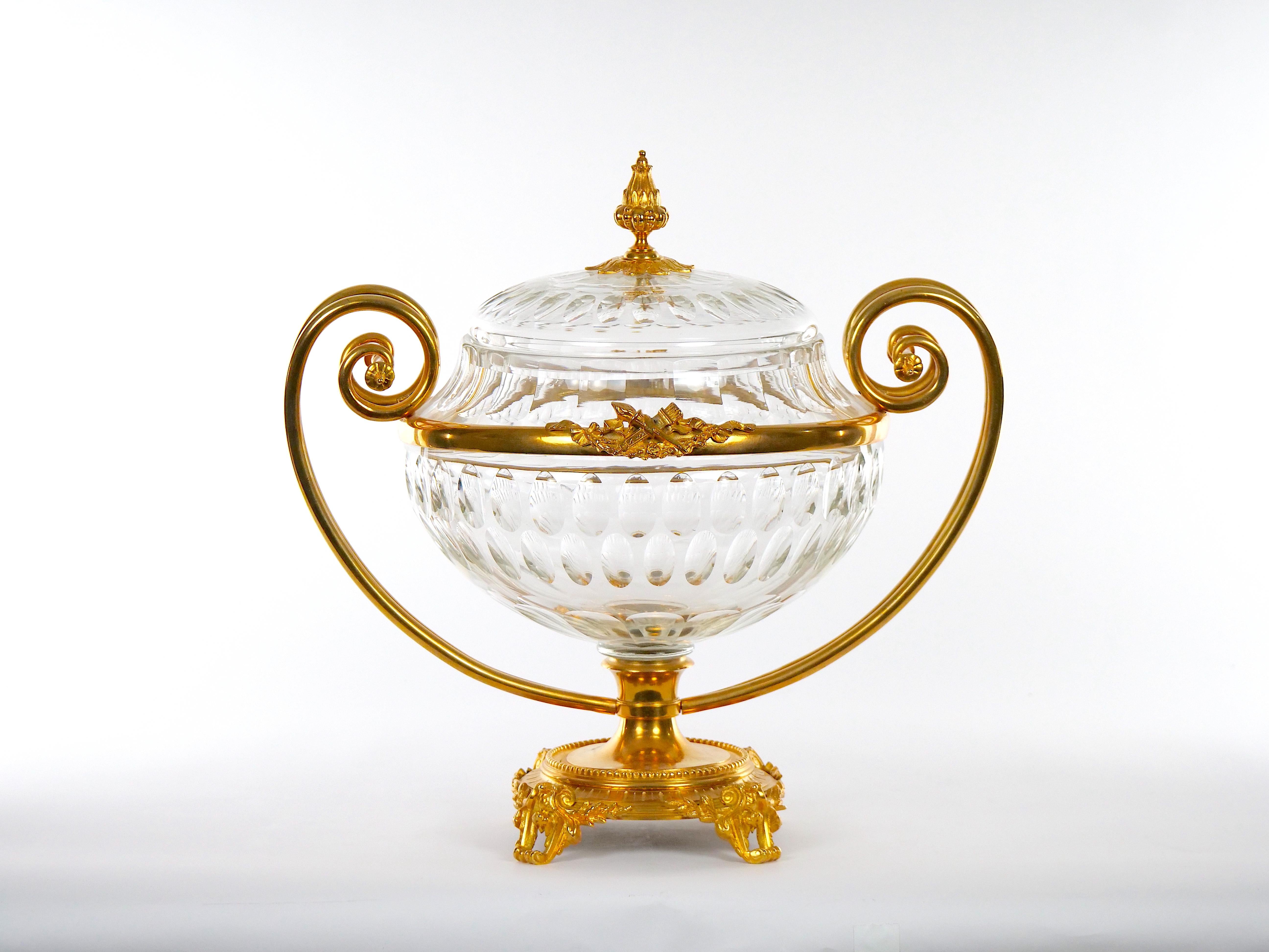 Wonderful French Empire gilt ormolu bronze mounted hand-cut crystal covered decorative Bowl. The centerpiece features a bright gilt bronze holding frame with double side handles with finial holding top resting on a footed round base. The diamond cut