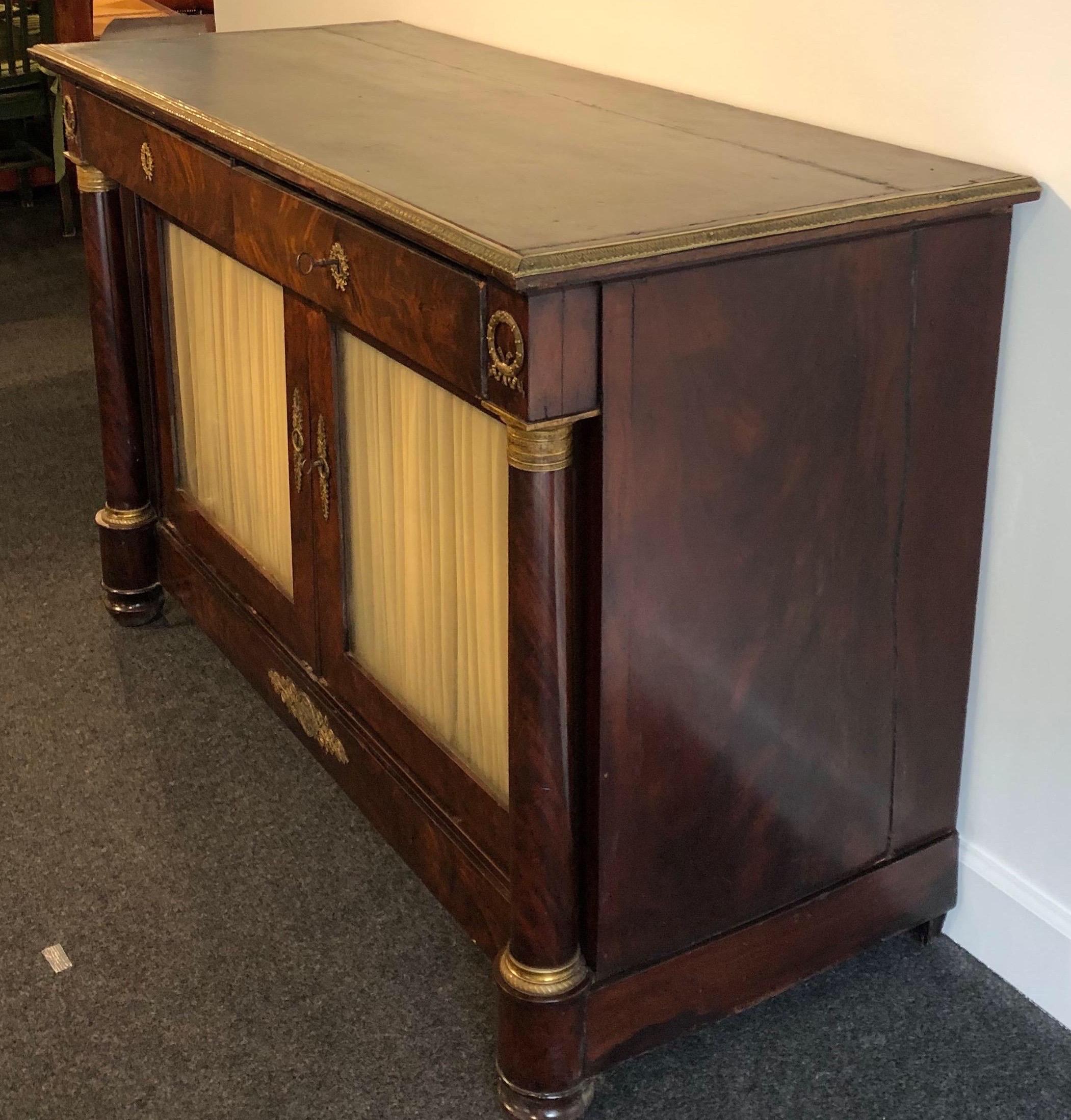 19th century French Empire cabinet with bronze mounts and leather top. 2 drawers over 2 door cabinet.