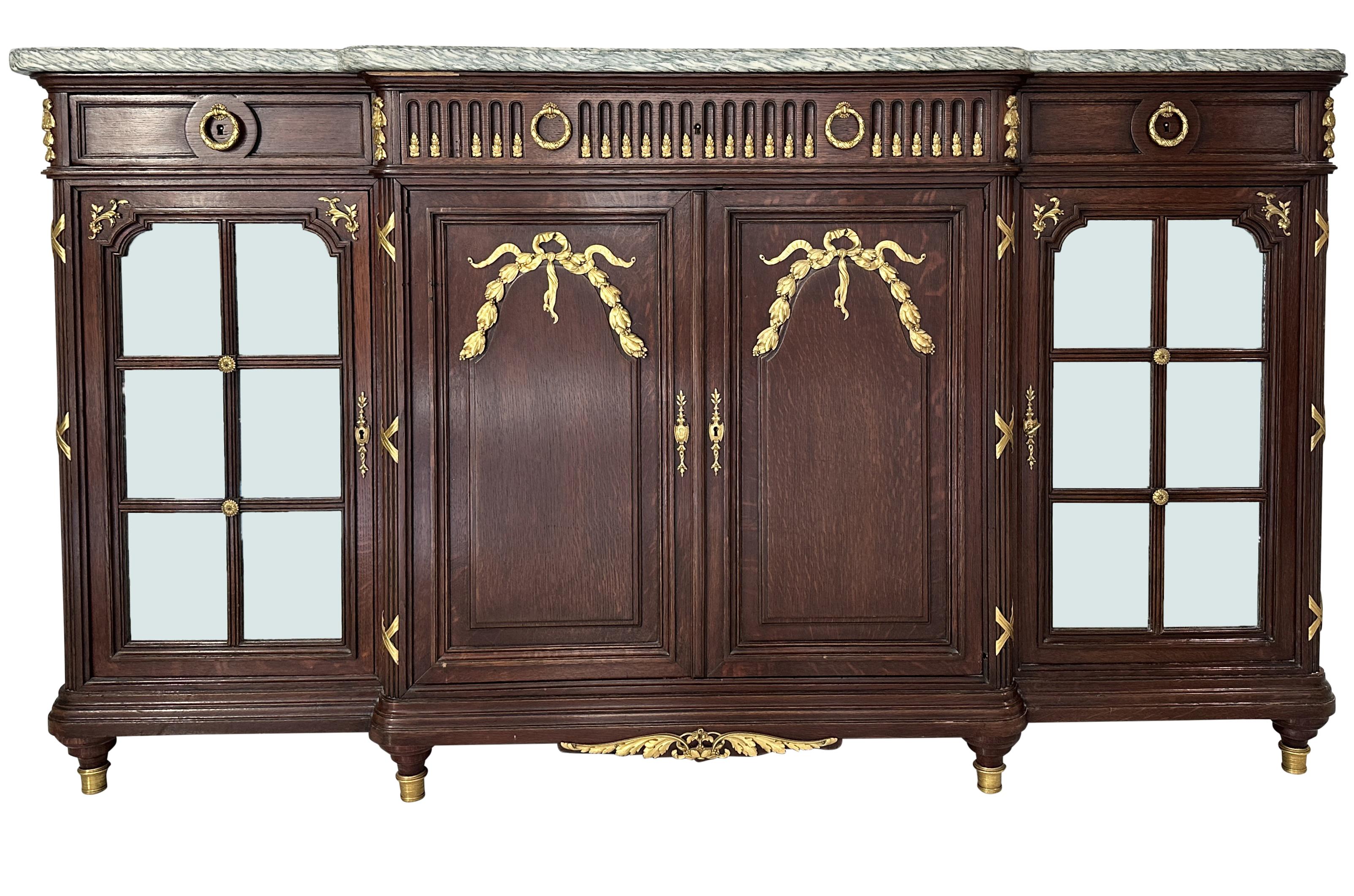 Antique 19th century gilt bronze mounted quarter sawn French oak marble top and mirrored enfilade buffet . Fine quality antique French buffet with carved fluted columns and gilt bronze mounts having your traditional Louis XVI motifs such as laurel