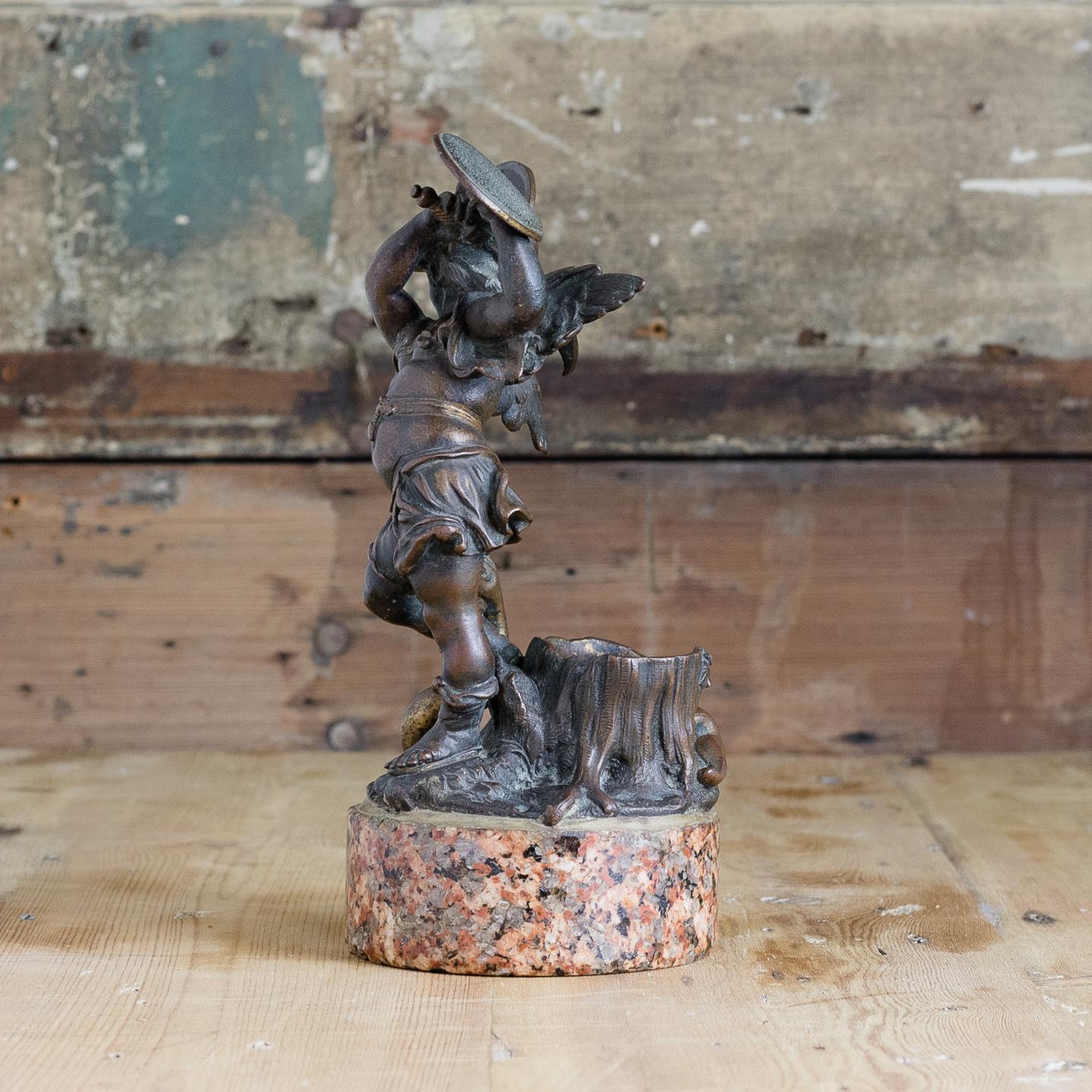 19th century bronze of the Heroic Putti, with traces of old gilding, modelled holding shield and sword aloft on circular Aswan marble plinth base, possibly German, after the originals from the Mariensäule column in Munich by Ferdinand Murmann.
     