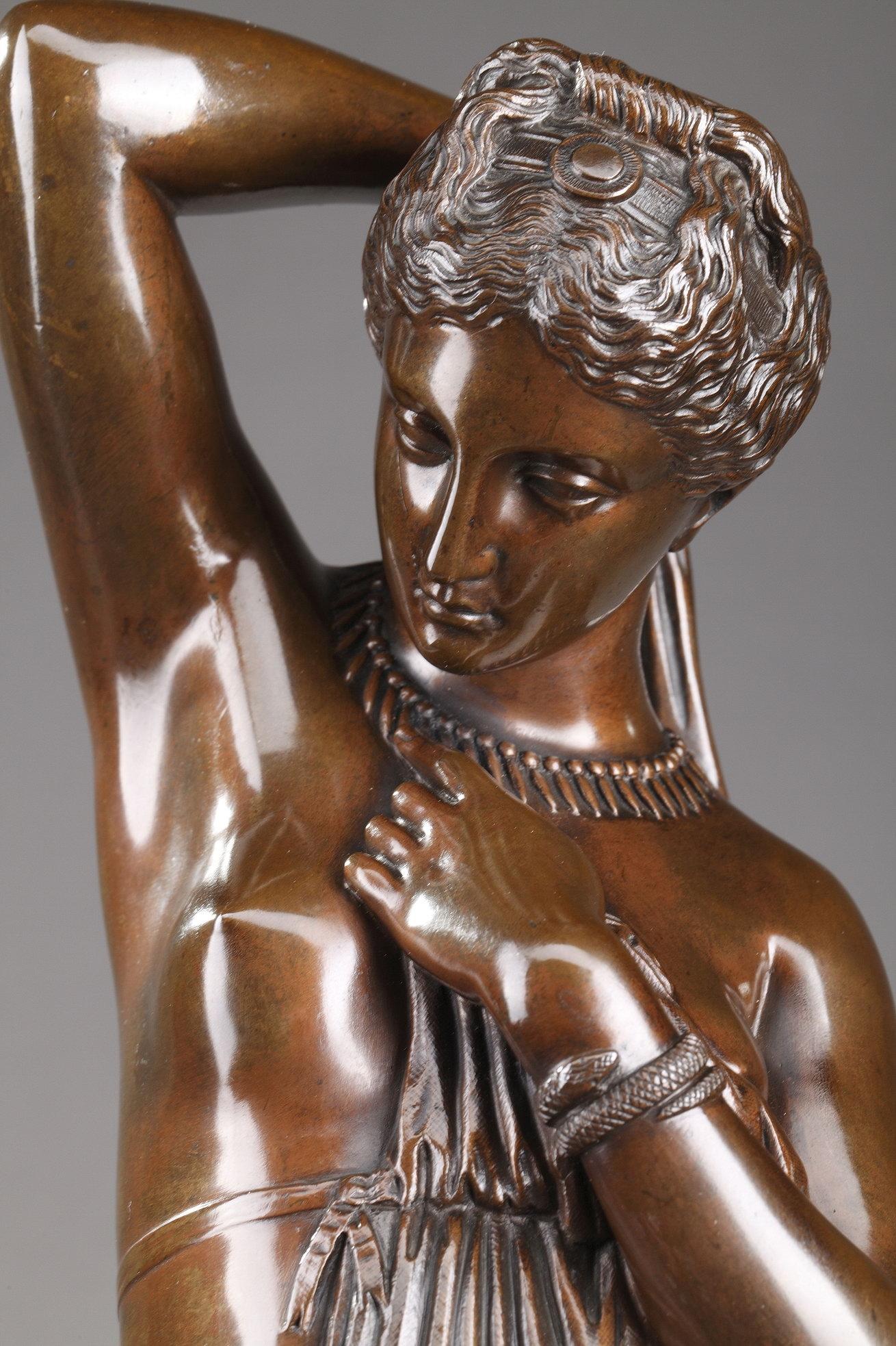 Bronze statuette with brown patina featuring the graceful Phryne, a legendary courtesan in ancient Greece put on trial for impiety. Phryne was acquitted after her defender Hypereides removed her robe and exposed her naked body to the jury. Our