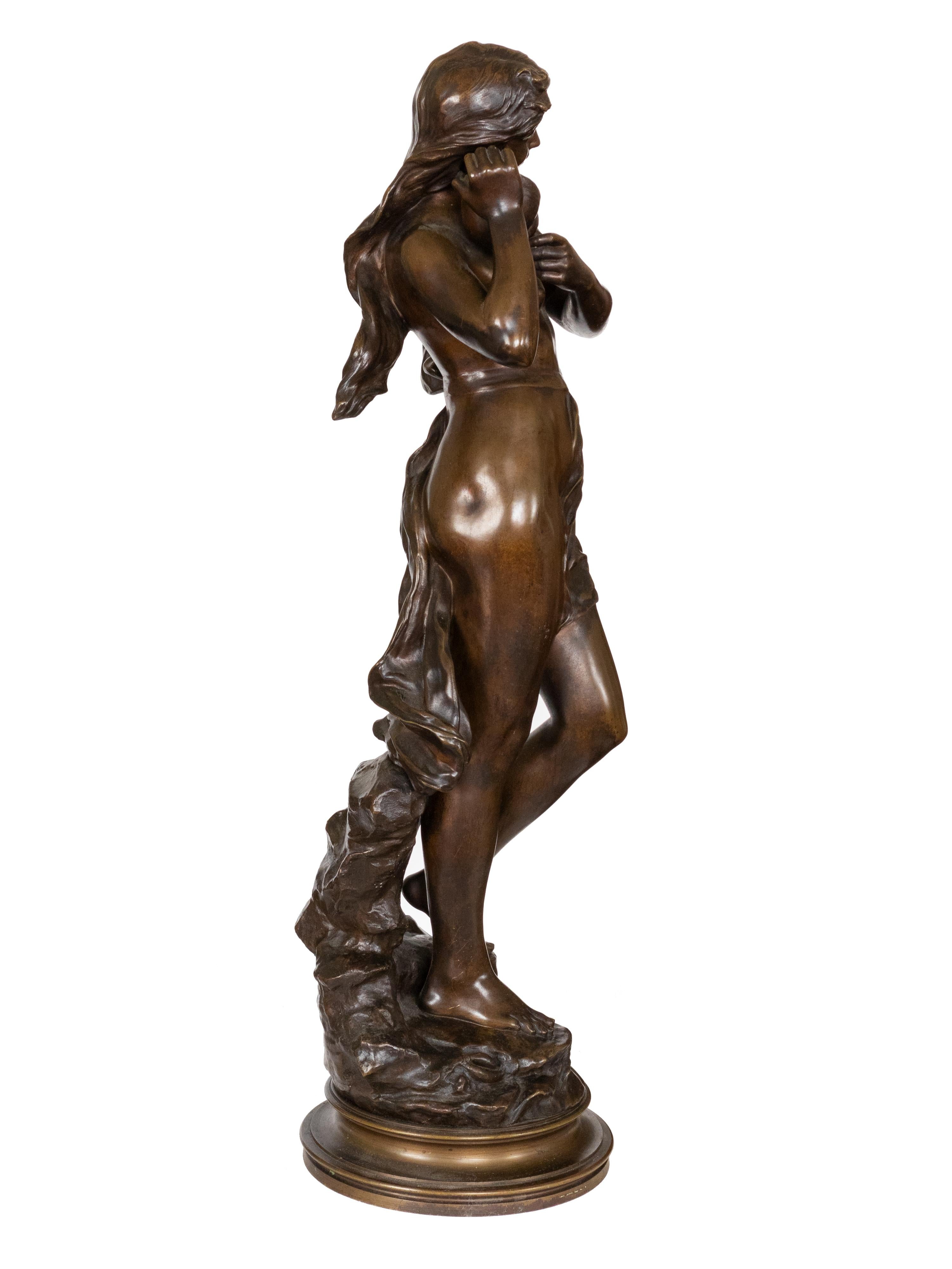 Eurydice, one of the Nereids, is depicted in a bronze statue from the 19th century. Her long hair flows freely amidst a rocky landscape and she wears a conch shell as an earring. The sculpture bears the signature «Eugene Marioton»