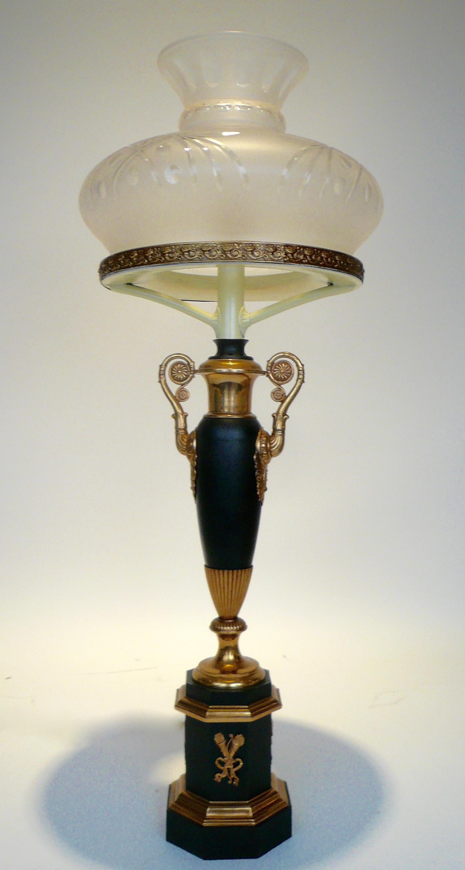 This handsome urn form sinumbra lamp retains it's original oil reservoir. It features neoclassical motifs including cornucopia, acanthus leaves and floral rosettes.
 