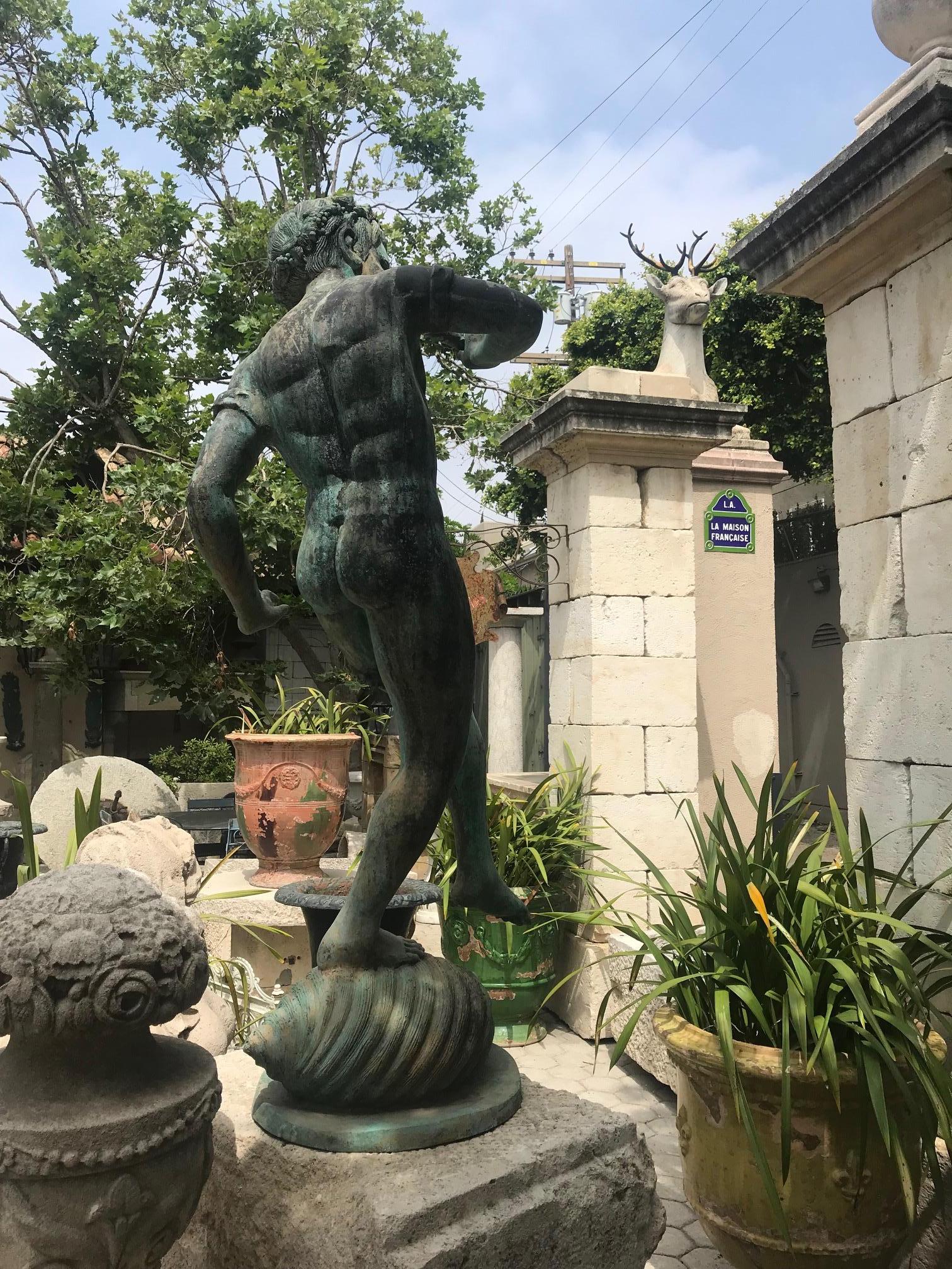 A beautiful 19th century large cast bronze of a boy’s figure blowing a Horn. The center fountain piece made with elaborate detailed wreath and flowers, blowing a Horn in his hand while standing on a Sea shell. It could be used around the pool area