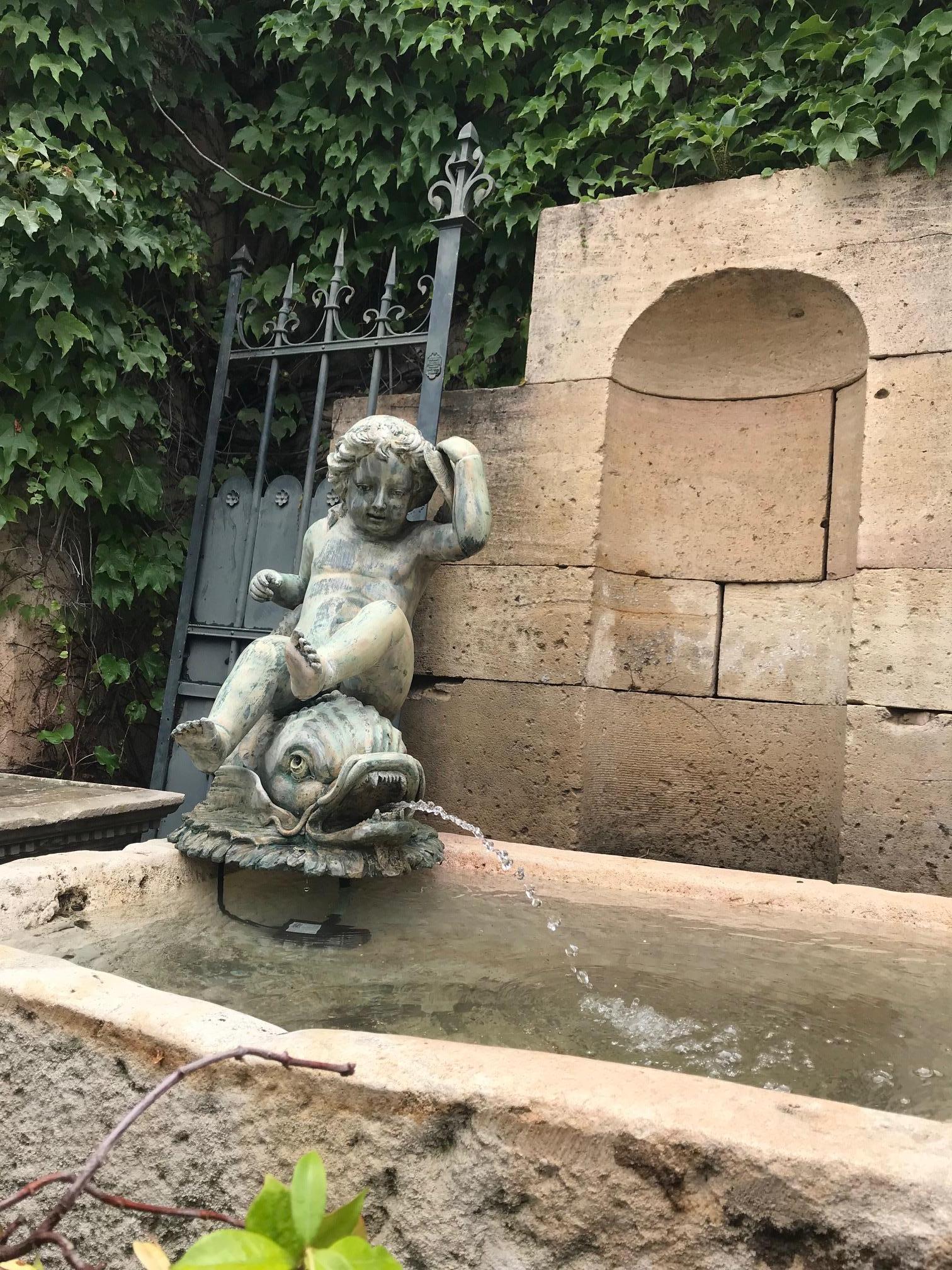 Very nice and detailed work of late 19th century cast bronze garden puttie Riding a Mythical Dolphin fish on the waves. The figure of the Angelo at play with the sea creature. They could be used around the pool area In the center of a pond or lake