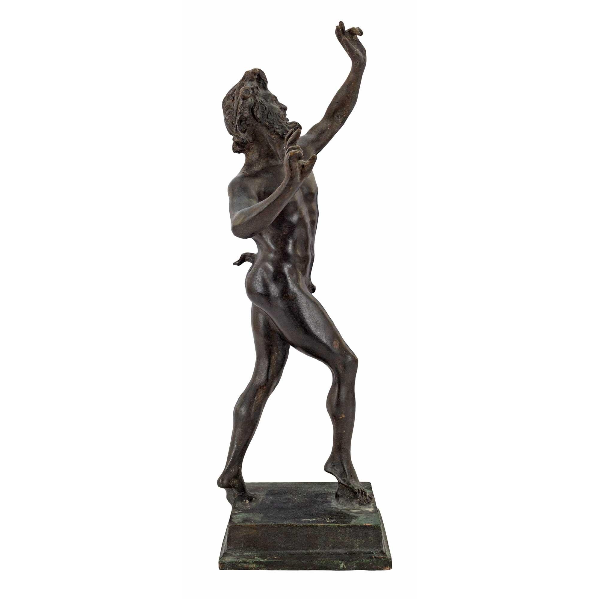 A 19th century bronze statue of a faun. Raised on a rectangular base this figure of a faun, with a man's body and the horns, pointed ears and tail of a goat appears to be looking upward as he runs with hands in the air. The statue is impressive with