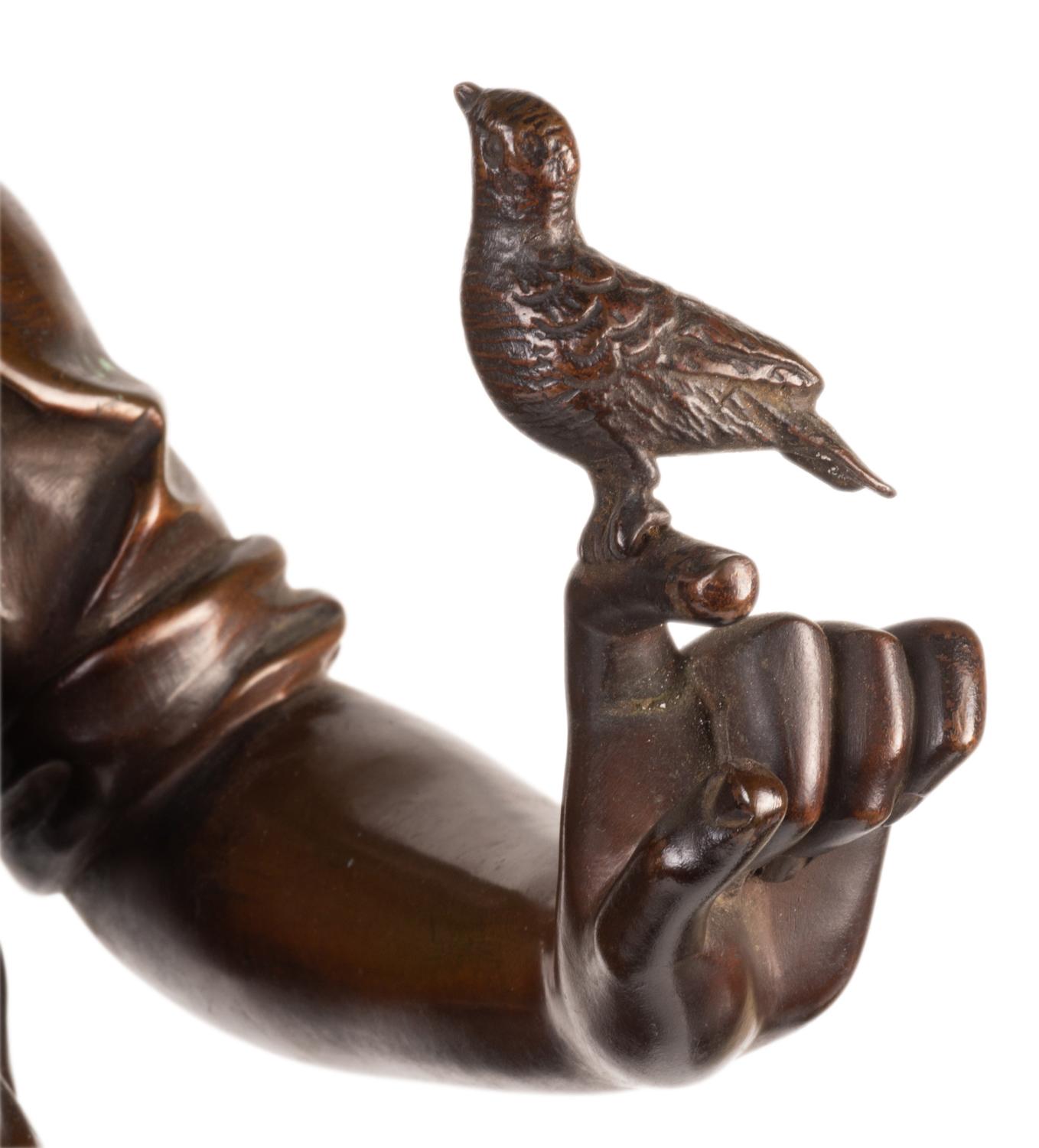 Statue en bronze de bonne qualité du XIXe siècle représentant un jeune garçon sifflant avec un oiseau perché sur sa main, intitulée 