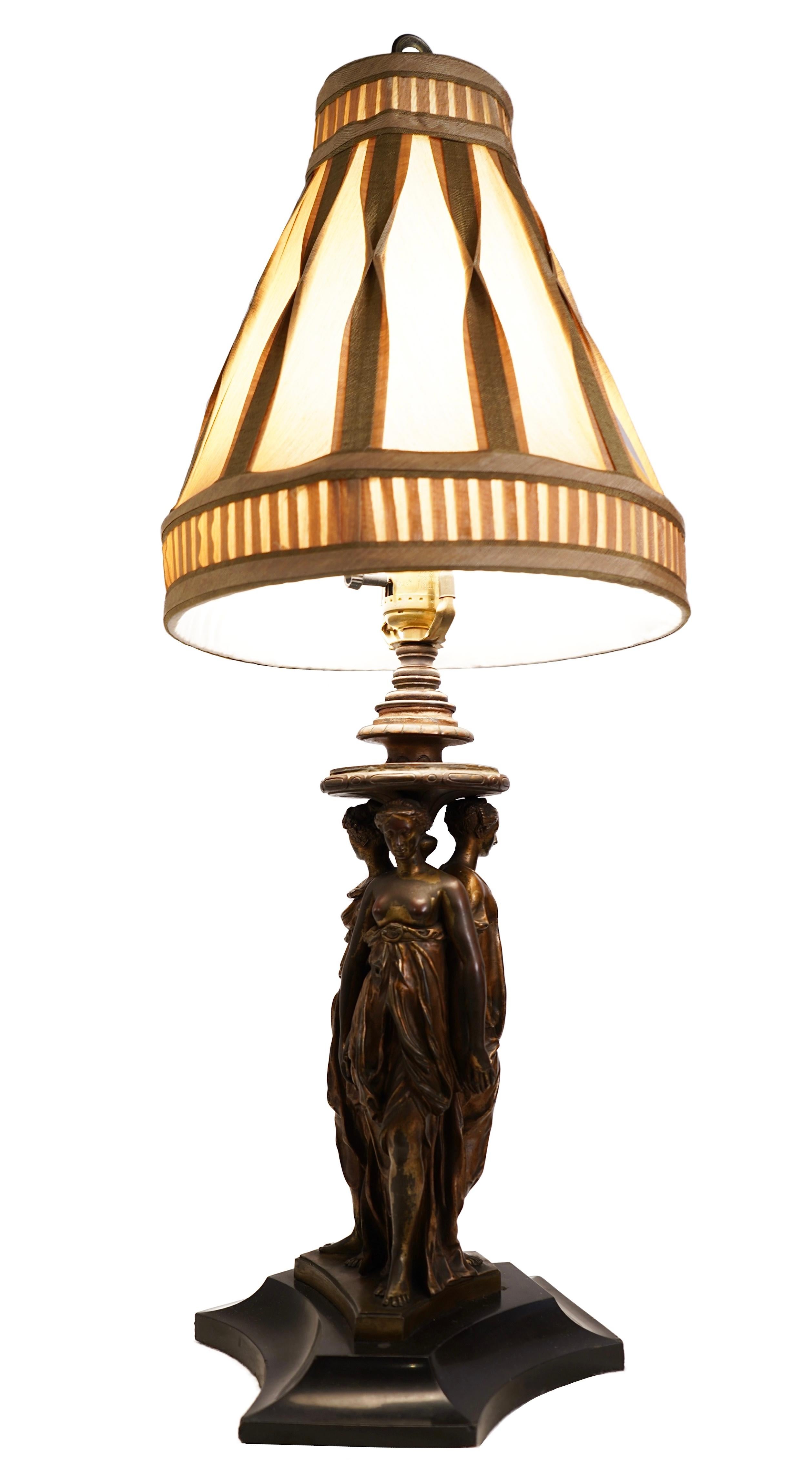 A late 19th century patinated bronze lamp with three goddesses.

Dimensions: 12