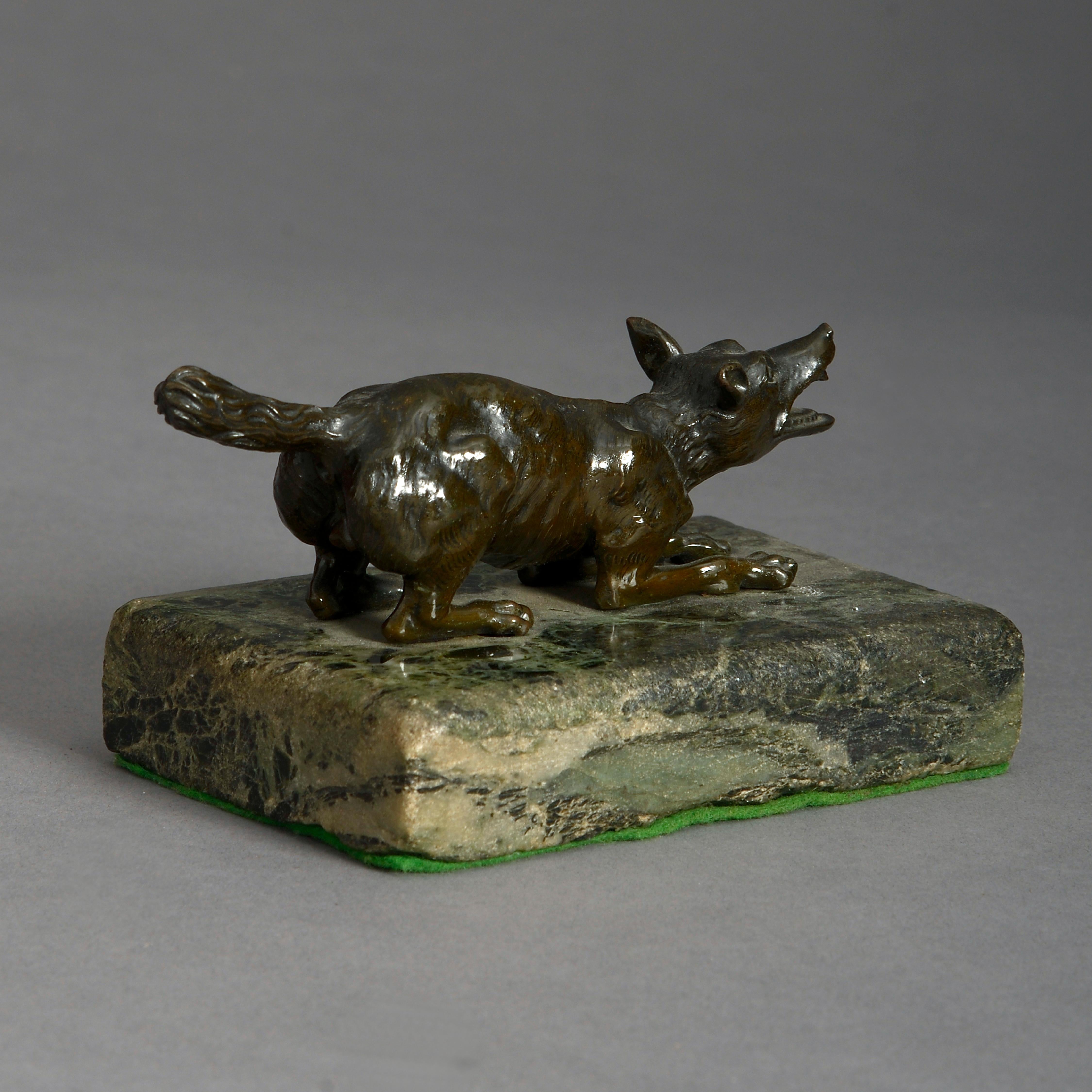 A mid-19th century bronze sculpture of a wolf, set upon a green marble plinth.