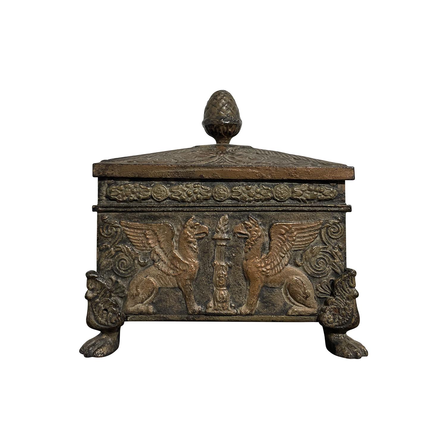 A dark-brown, black antique German coffer made of hand crafted iron, particularized with griffins, torchères and tendril motifs on the wall and pinecone mode on the lid, in good condition. The small detailed decor piece represents the Empire time