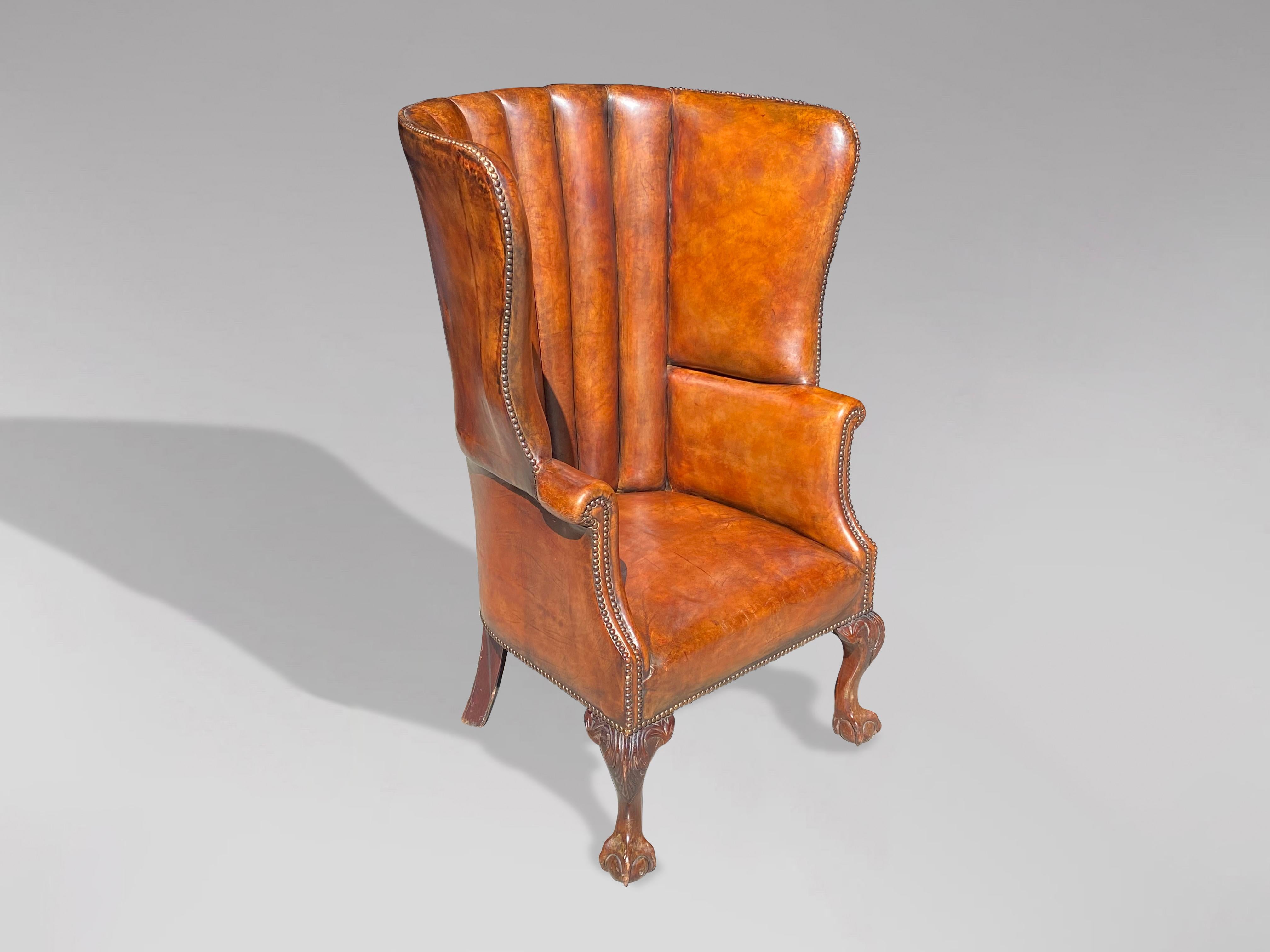 A late 19th century good quality English golden brown leather barrel back armchair with beautifully shaped back with brass studwork, all standing on mahogany front cabriole ball-and-claw feet. Warm rich colour and patina! Very comfortable seating.