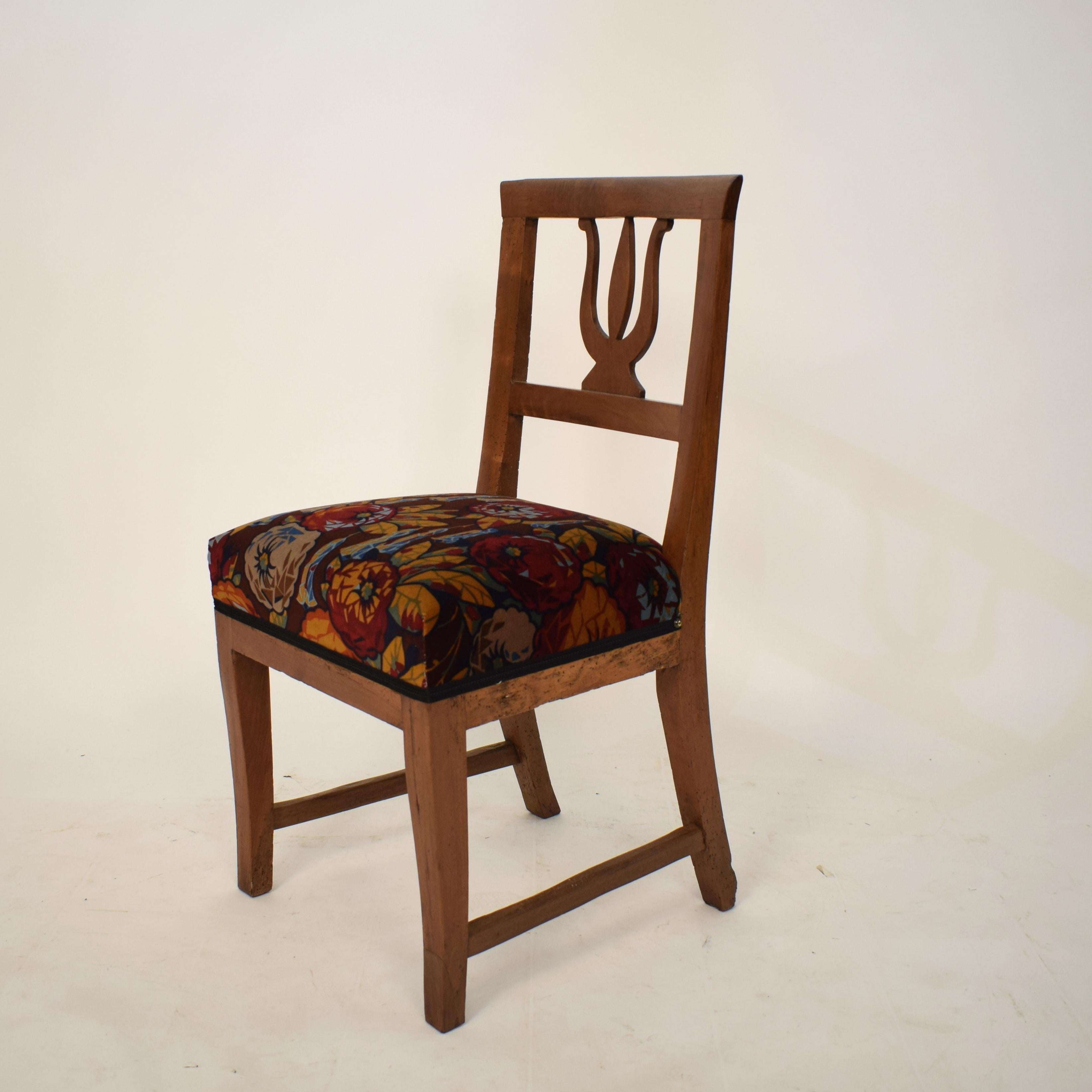 This beautiful 19th century Italian Biedermeier side or dining chair was built in 1820. The chair is made out of brown walnut wood. 
It is newly upholstered in velvet with flower pattern.
A unique piece which is a great eyecatcher for your