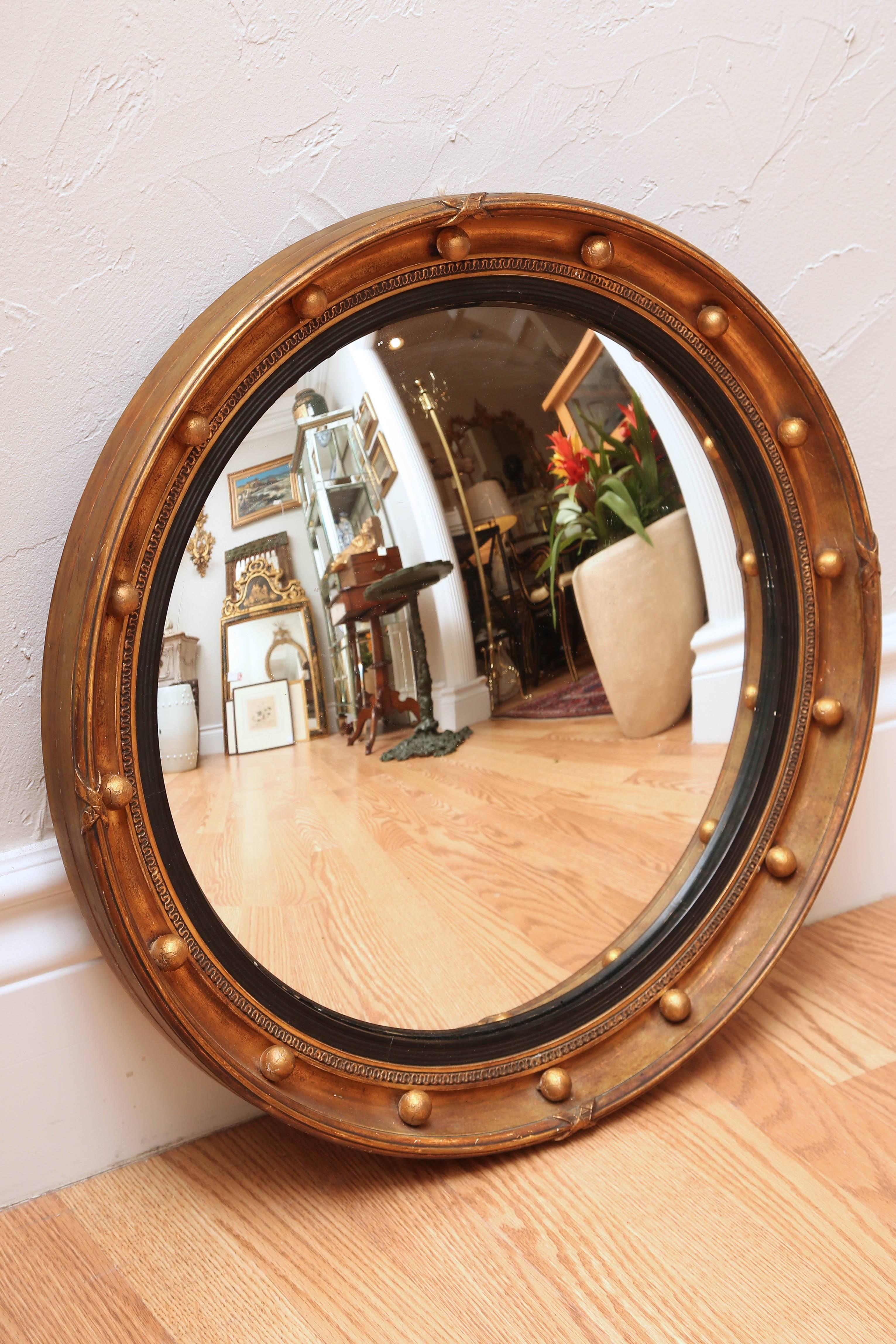 Antique carved and gilded convex mirror.