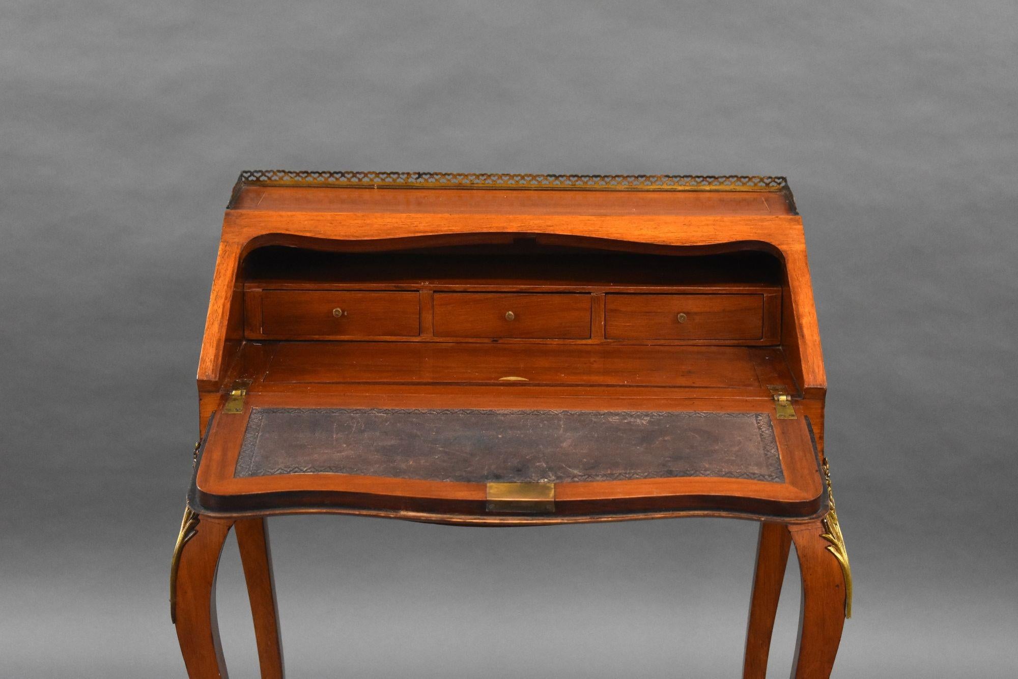 19th Century French Bureau De Dame in good condition with brass gallery to the top and decorative inlay to the fall that pulls down to reveal three small drawers and fitted leather writing surface. The bureau stands on elegant legs with ormolu