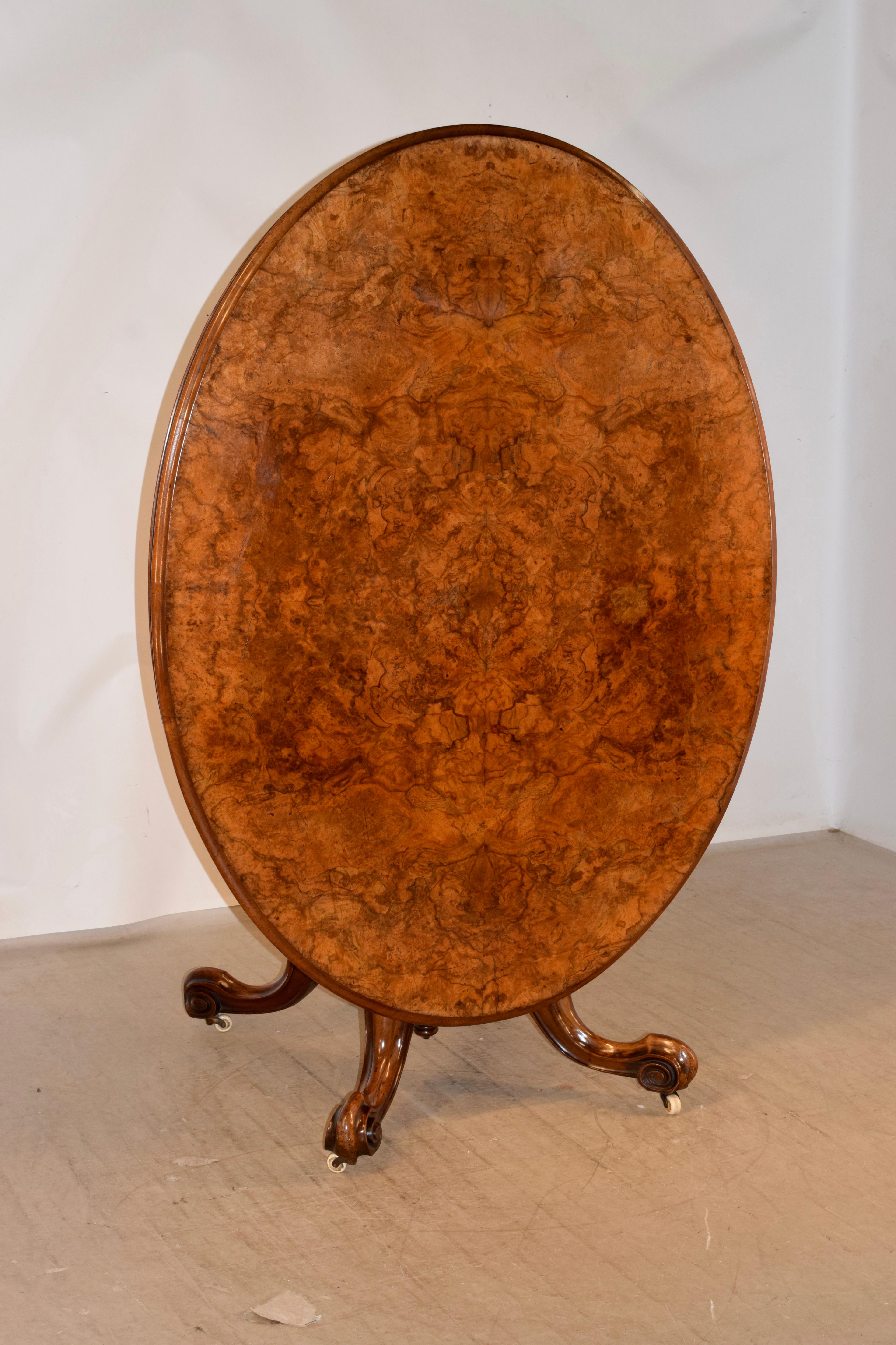 19th century burl walnut tilt-top breakfast table. The top is exquisitely grained and has a beveled edge, over a burl apron. The table is supported on a fluted decorated column which has wonderful raised carvings as well. The base is supported on