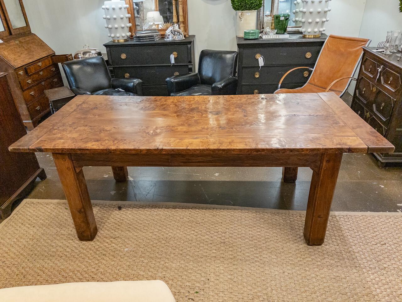 Transport yourself to the rustic elegance of 19th-century France with this exquisite French farm dining table. Crafted from rich burl walnut, this table exudes timeless charm and warmth. Its sturdy construction speaks of the artisanal craftsmanship