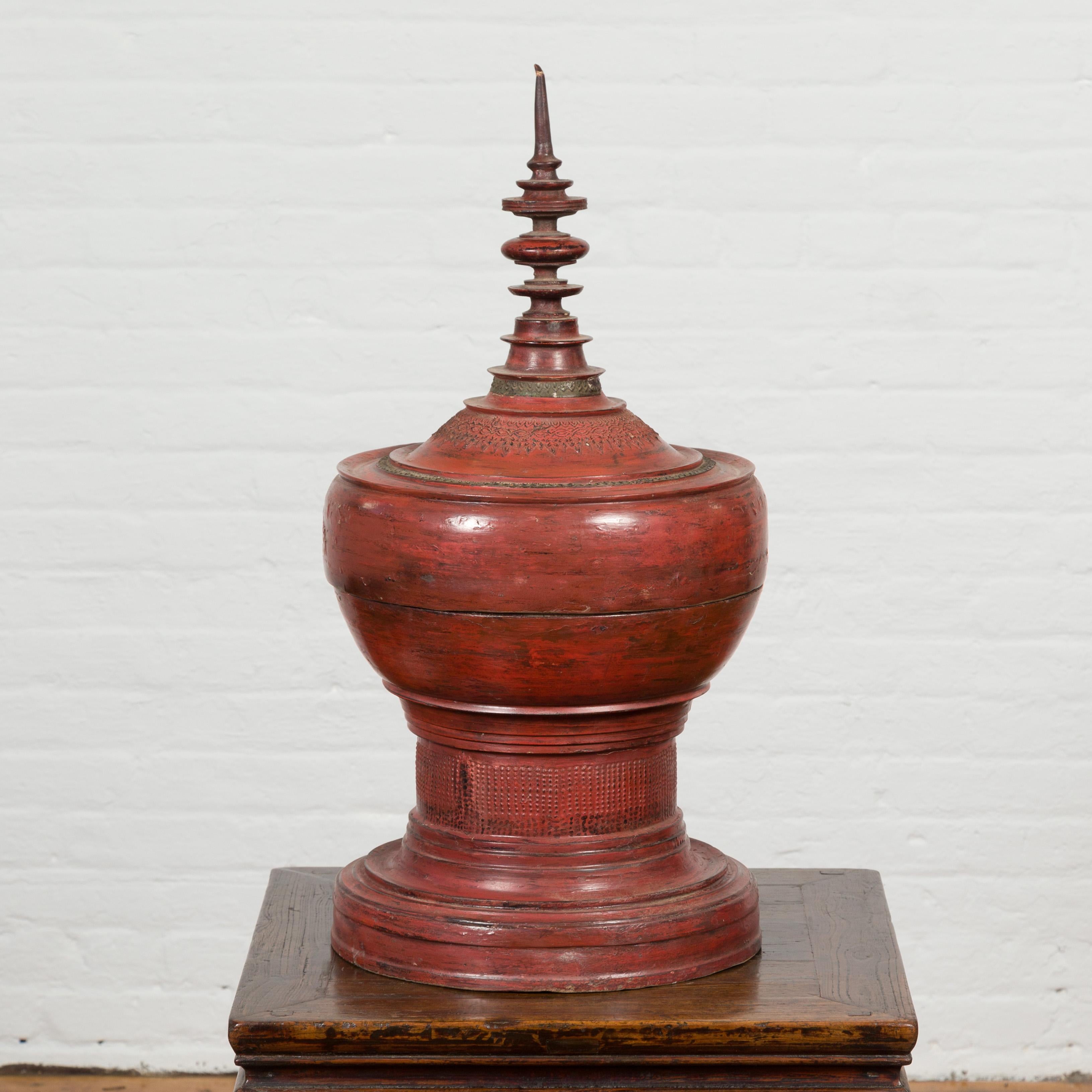 A Burmese cinnabar Palembang lacquer temple offering bowl from the 19th century, with spindle top. Created in Burma during the 19th century, this temple offering bowl is adorned with Palembang lacquer. Showcasing a (slightly crooked) spindle top,